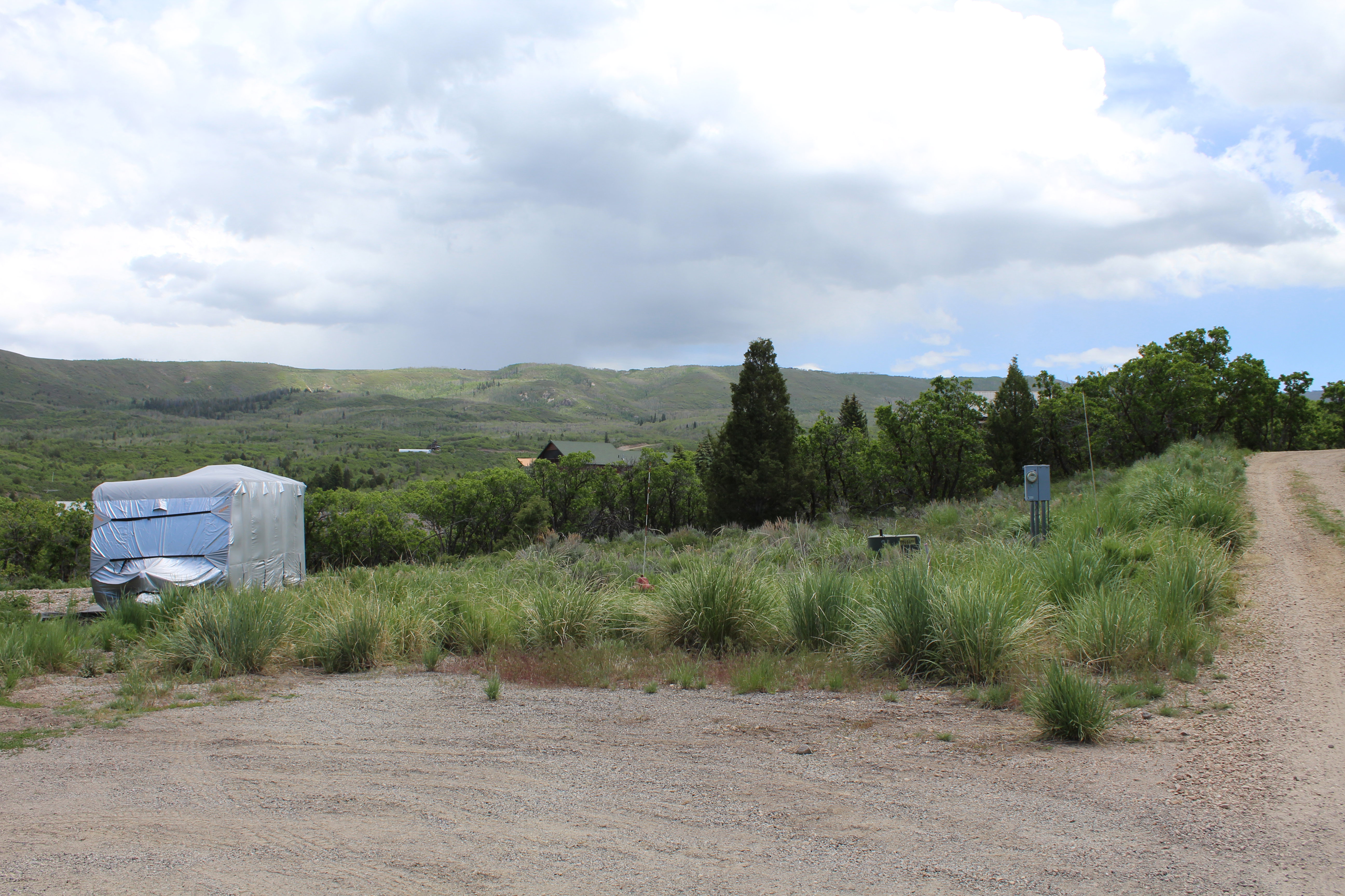 Gravel lot featuring natural landscaping and distant mountainous terrain