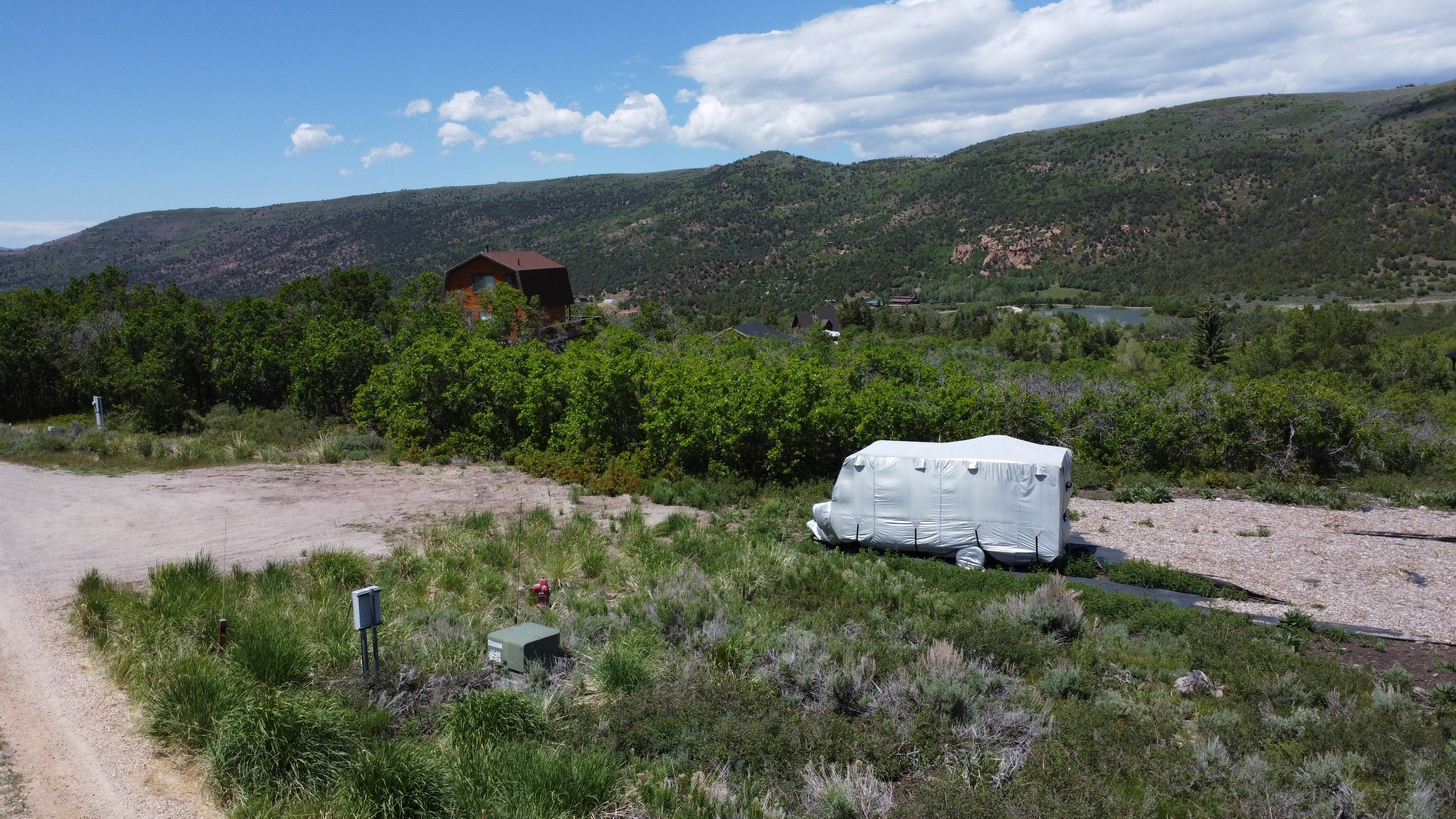 Rural property featuring a partial gravel driveway and surrounding natural vegetation