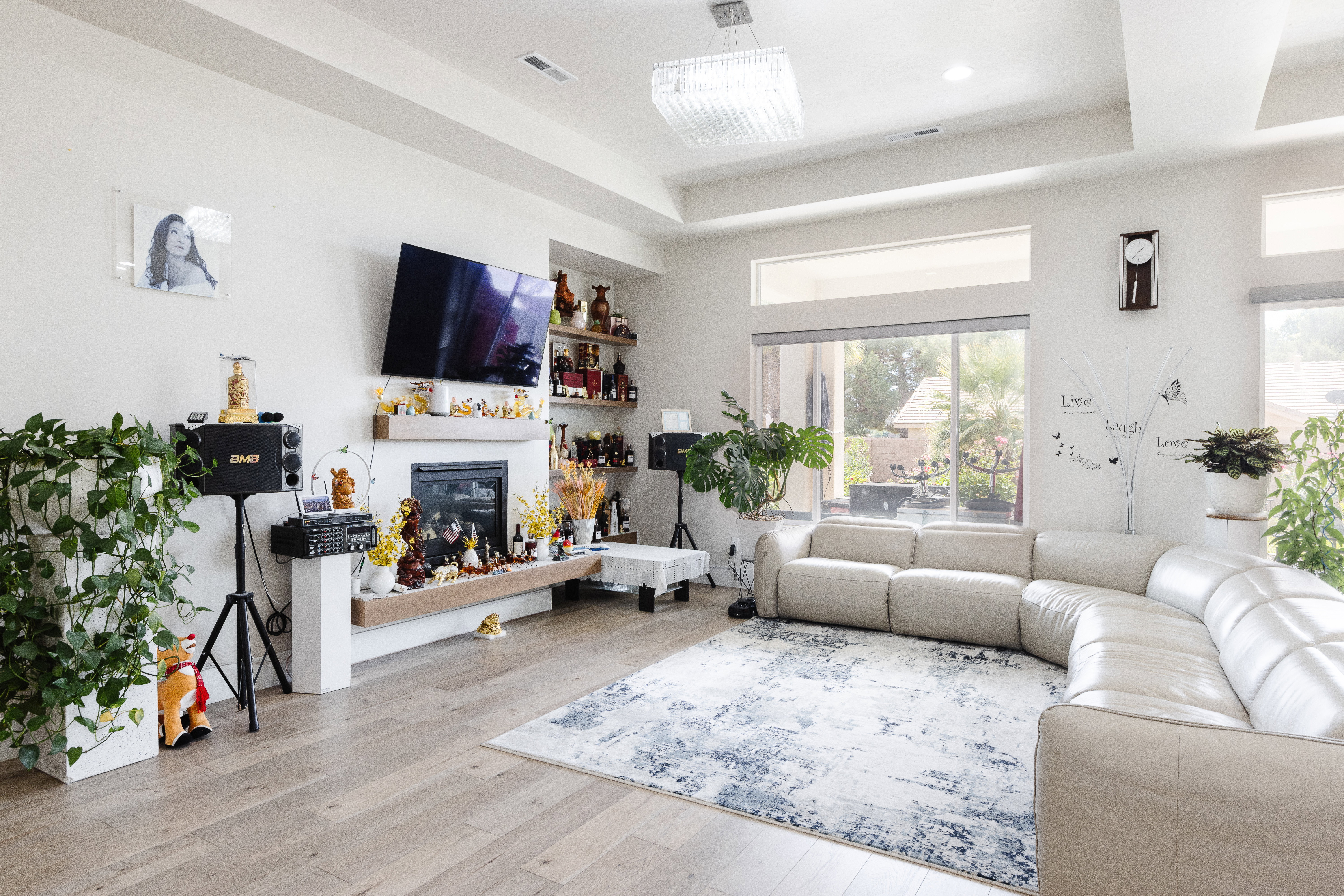 Living area featuring wood-finish flooring, a contemporary fireplace with a built-in floating mantel, recessed lighting, and a modern chandelier