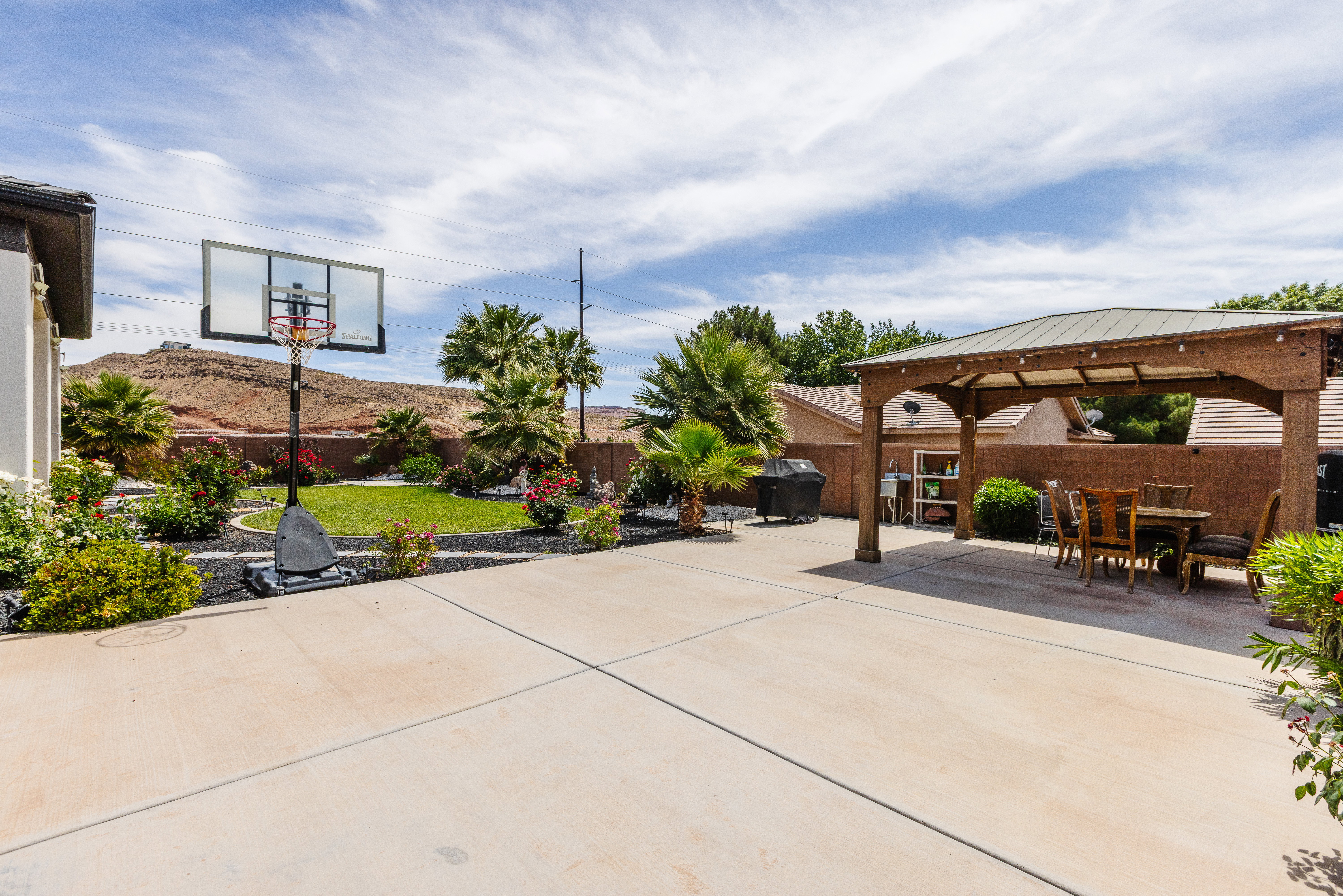 Expansive concrete patio area featuring a wooden gazebo with integrated lighting