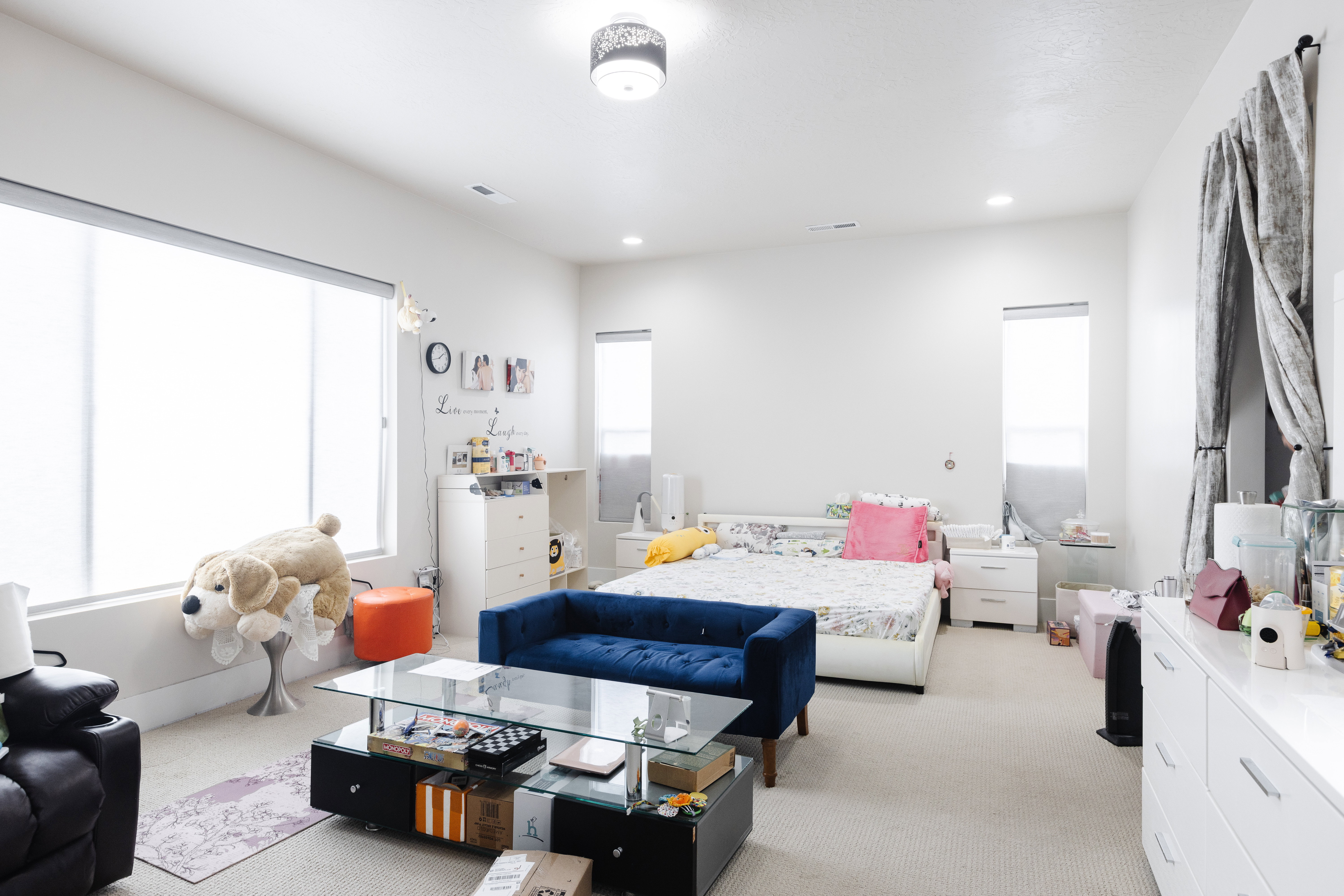Spacious room featuring light-colored carpeting, high ceilings with recessed lighting, and a contemporary ceiling fixture