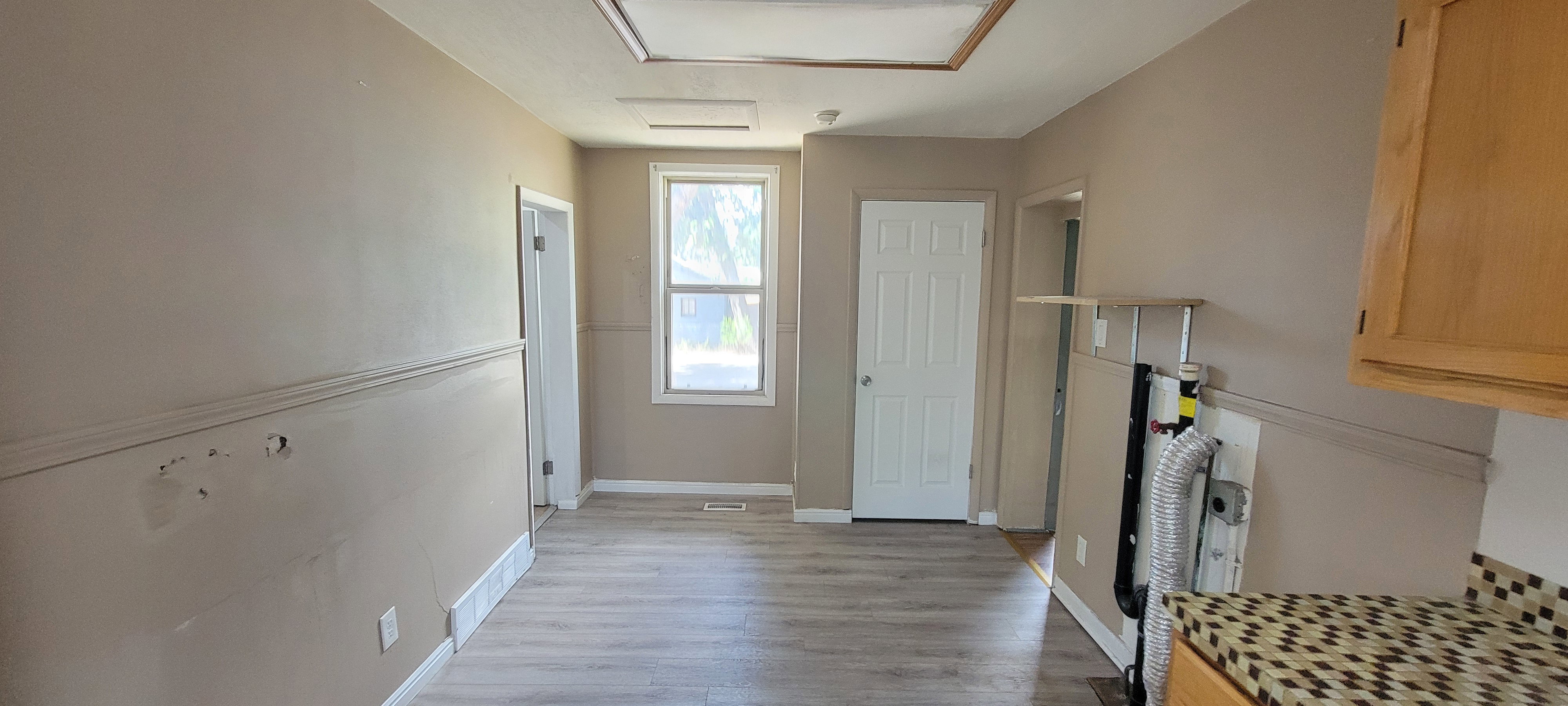 Neutral tone walls featuring chair rail molding, wood-finish flooring, and white trim throughout