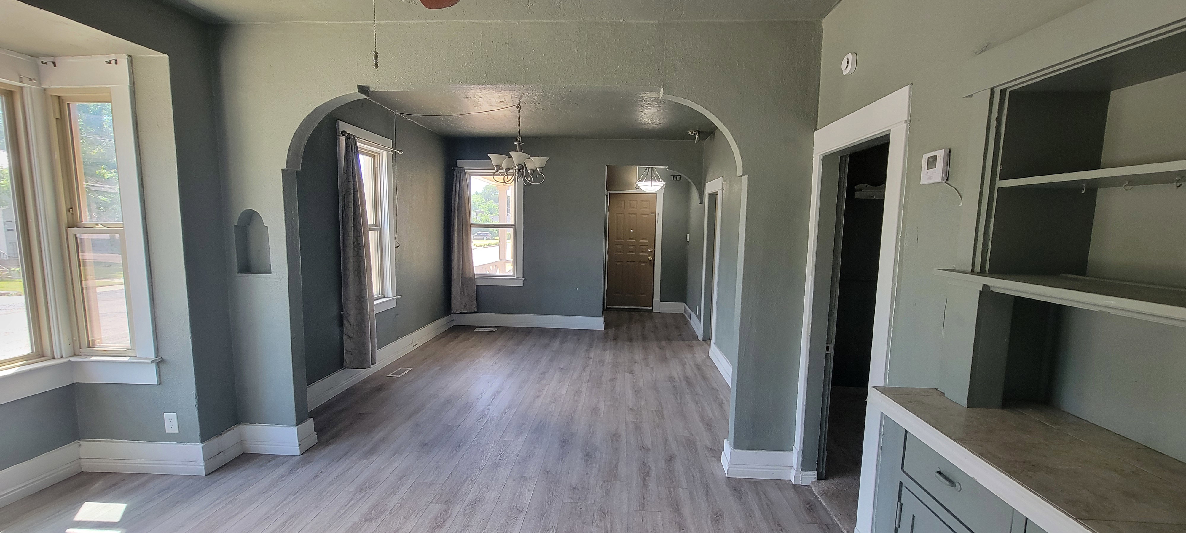 Spacious interior featuring light wood-finish flooring and arched doorways