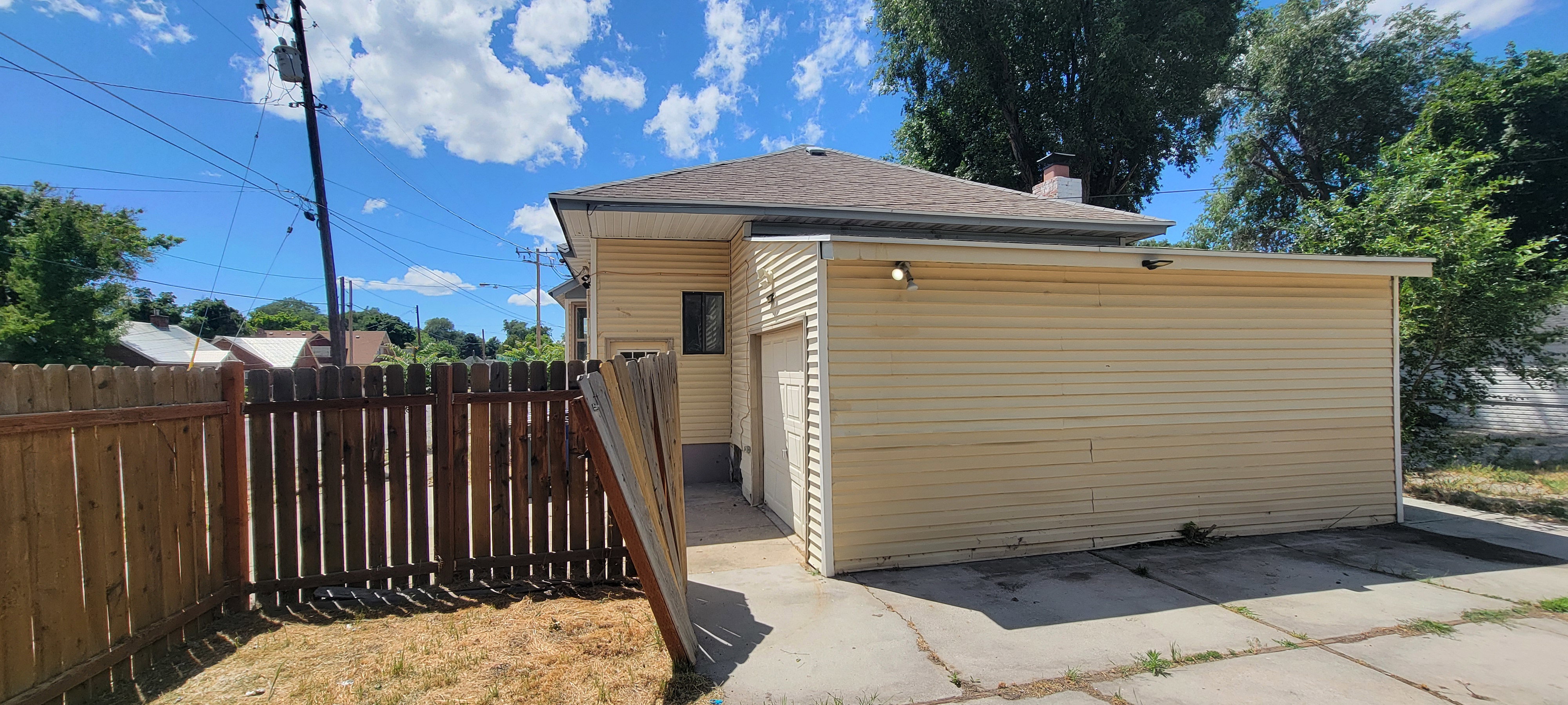 Detached garage featuring horizontal siding and an exterior light fixture