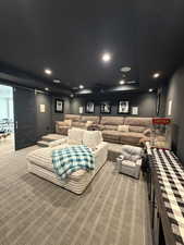 Dedicated media room featuring tiered seating, recessed lighting, and a barn door entry