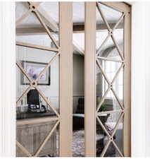Custom wood-frame pocket doors with geometric grilles and clear glass panels