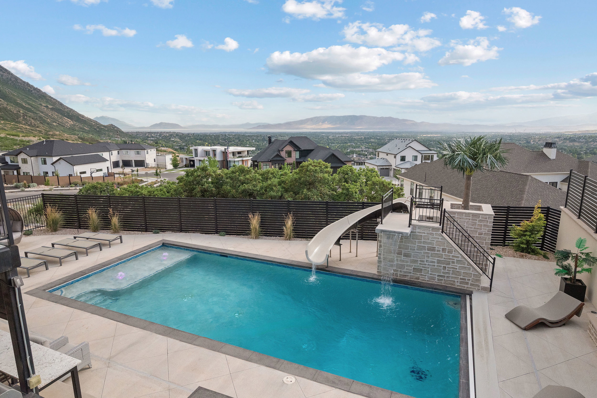 Outdoor swimming pool with a sun shelf and integrated slide