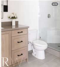Neutral-toned vanity with a solid surface countertop and matte black hardware
