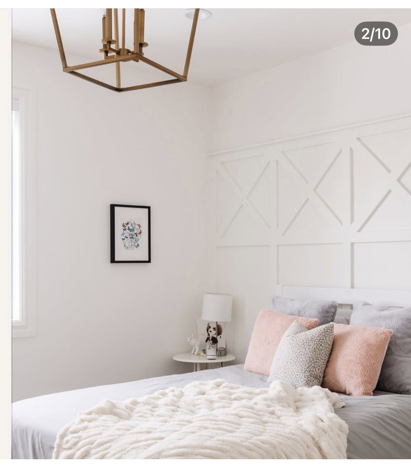White bedroom featuring a decorative accent wall with geometric paneling