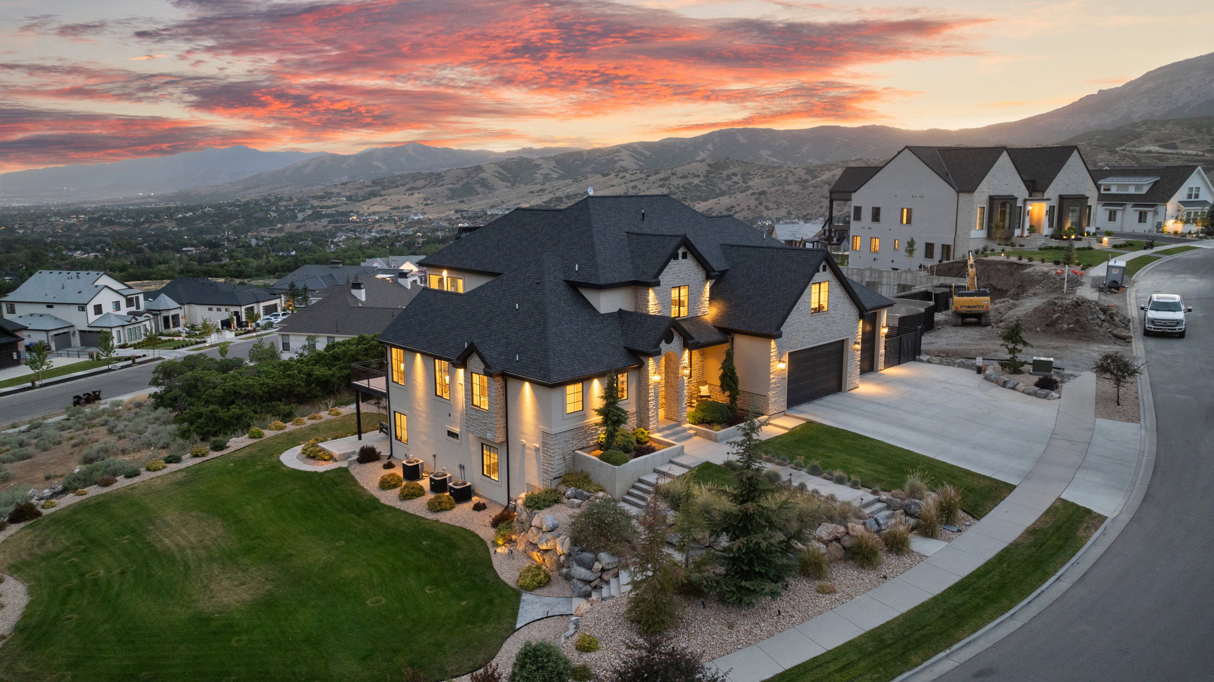 Modern residence featuring stone and stucco exterior, multiple gables, a three-car garage, and a concrete driveway