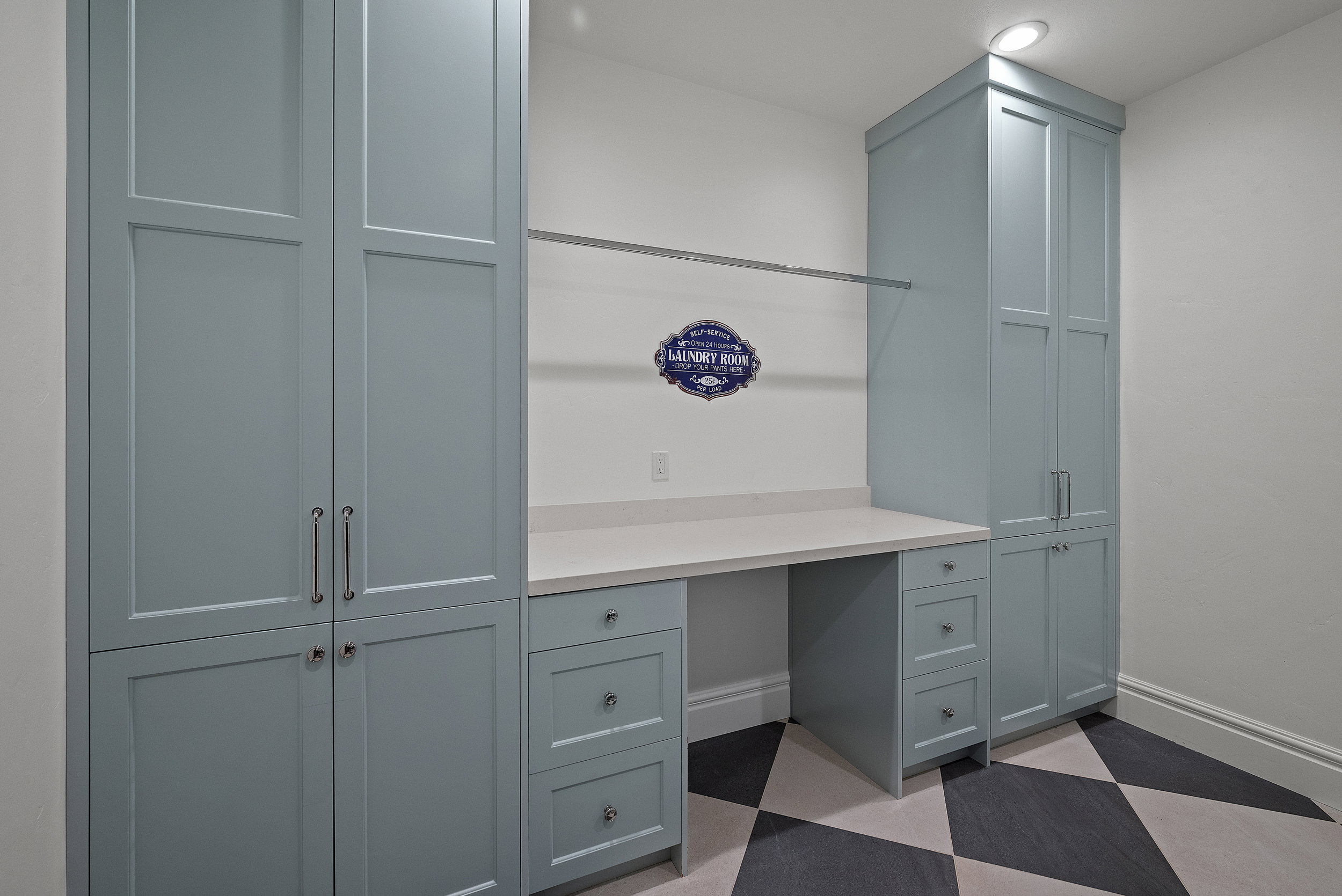 Built-in cabinetry with ample storage, integrated countertop workspace, a hanging rod, recessed lighting, and patterned flooring
