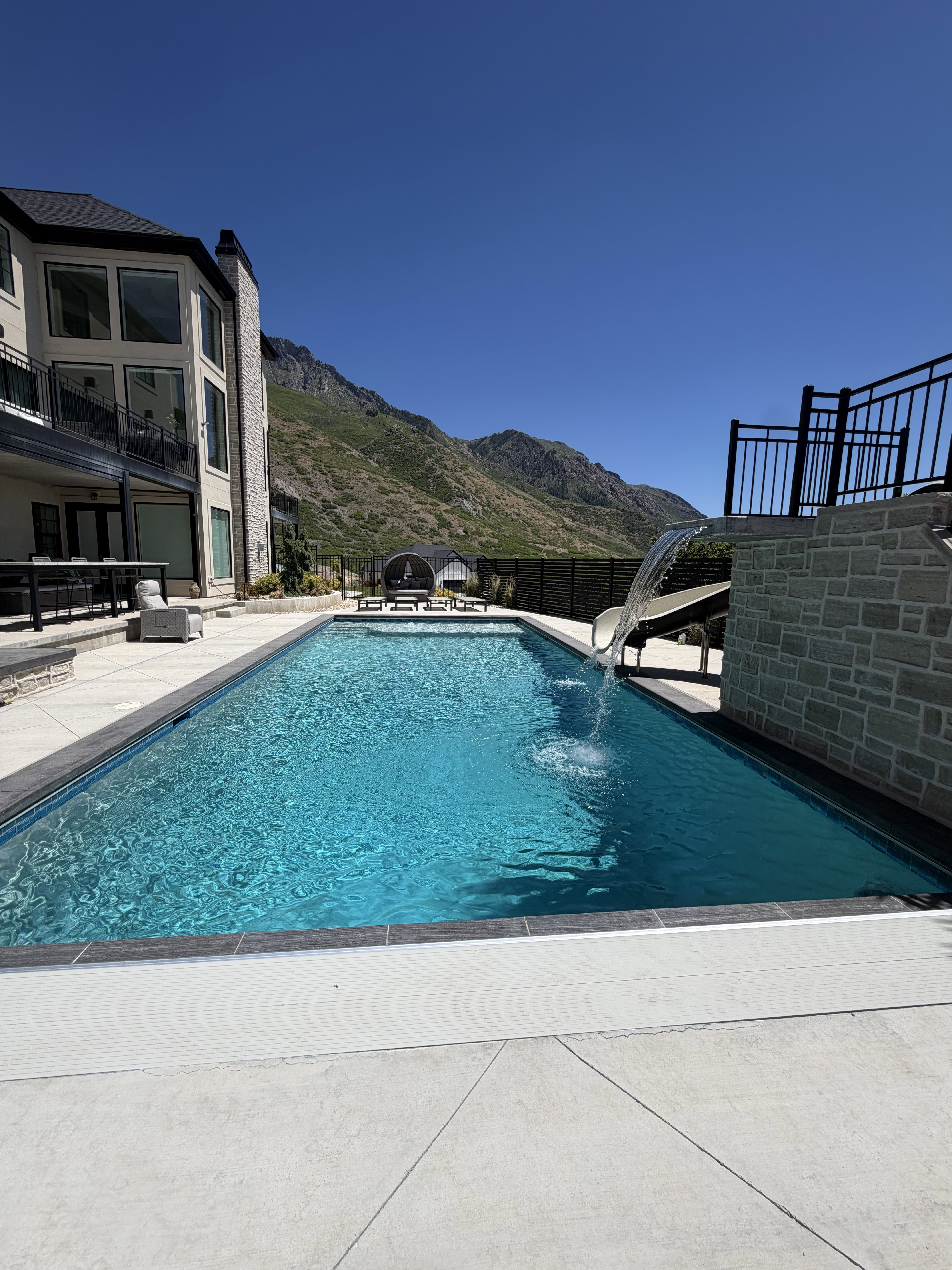 Rectangular inground pool with integrated spa and waterfall feature
