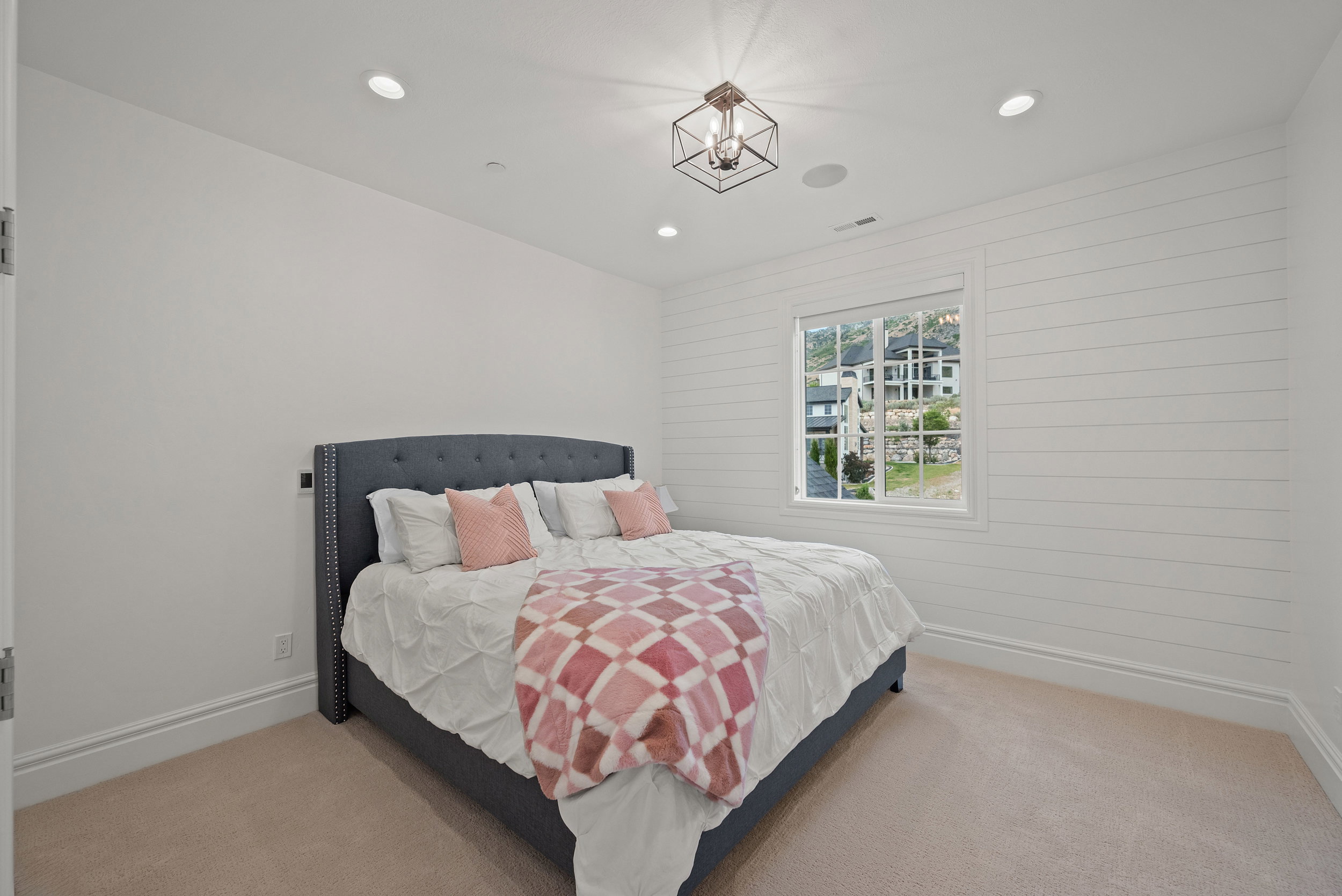 Room featuring shiplap accent wall, recessed lighting, and a square window with grid panes