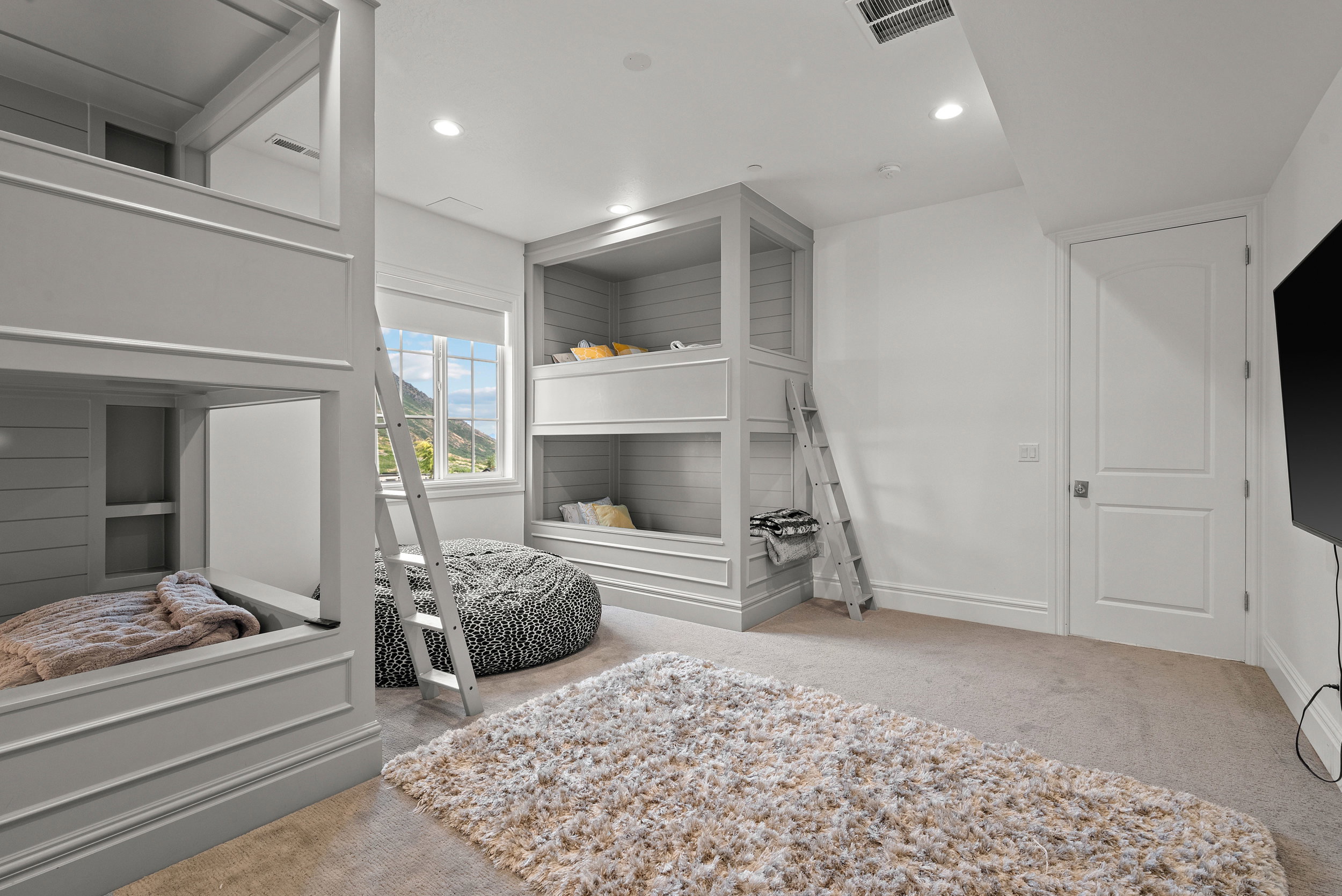 Custom built-in bunk beds with paneled construction and integrated ladders