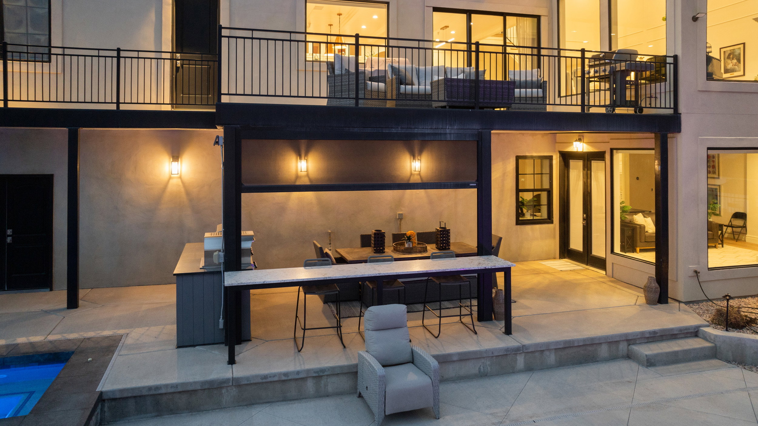 Outdoor kitchen and dining area with an integrated bar, concrete patio, and in-ground spa