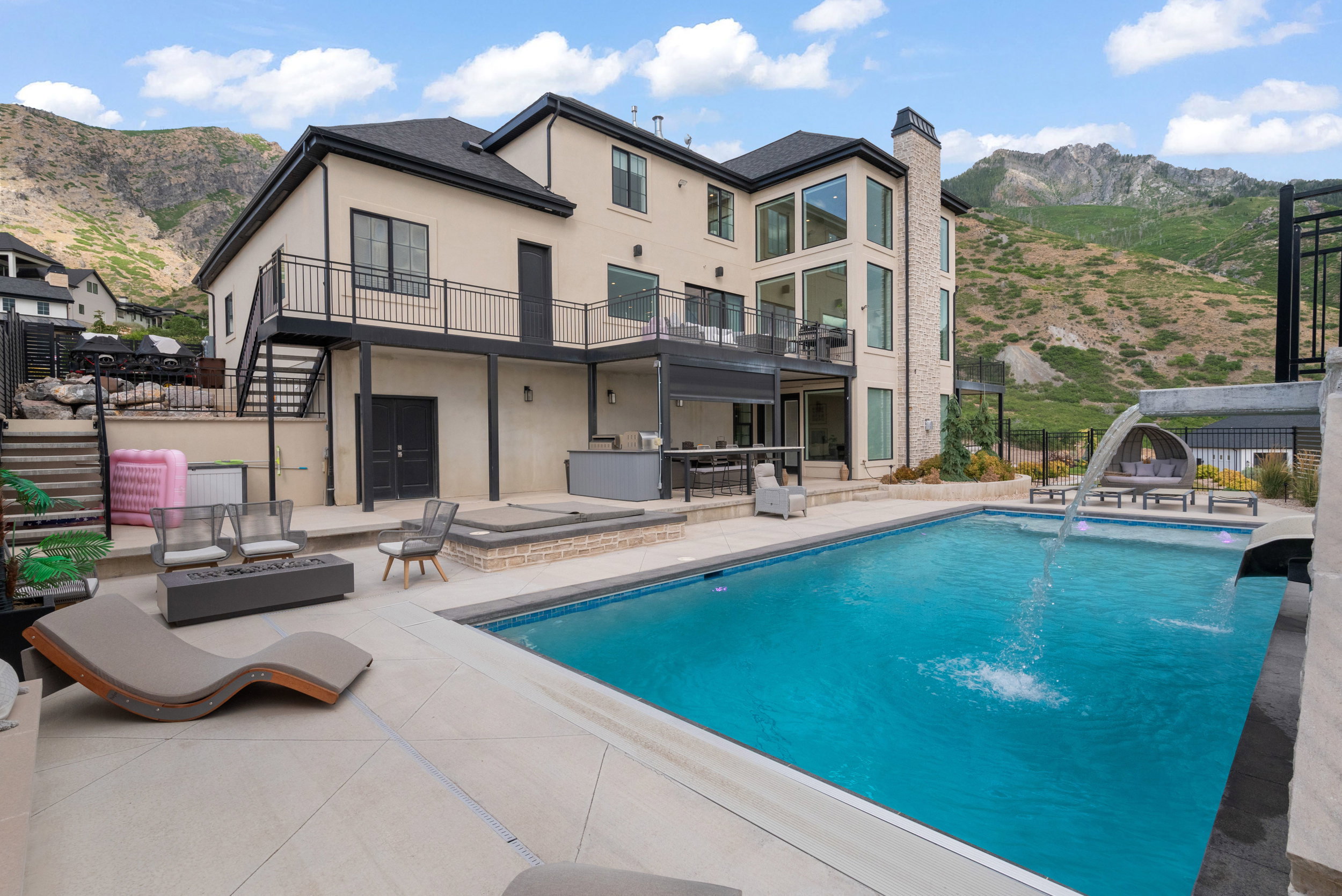 Expansive backyard oasis featuring a large swimming pool with water features, integrated spa, and a multi-level patio