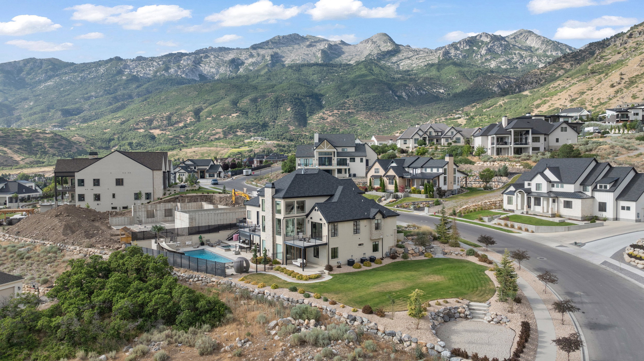 Hillside property with a private pool, an expansive lawn, and balconies offering mountain scenery