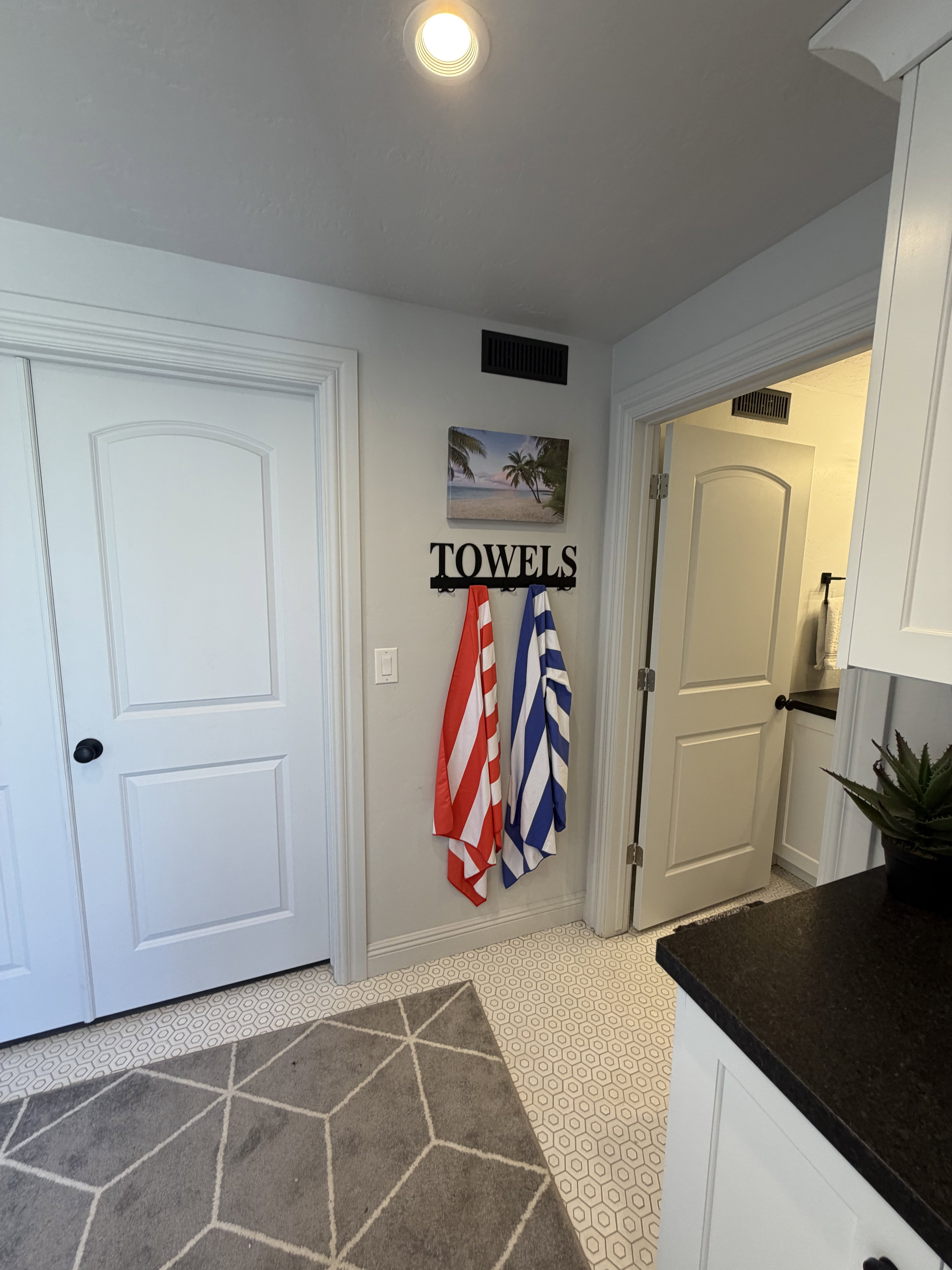 Recessed ceiling lighting illuminates a white honeycomb tile floor