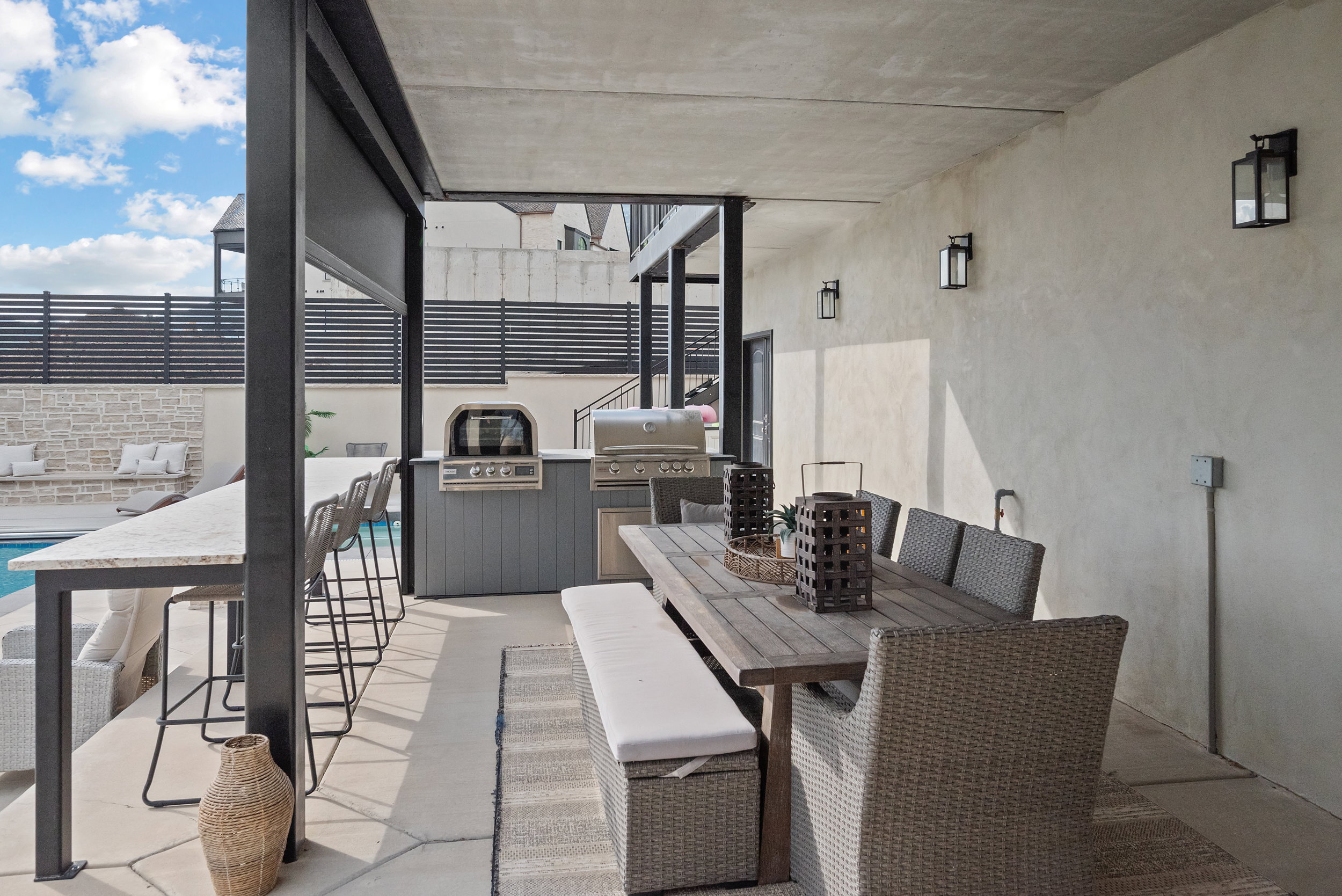 Covered outdoor living area with concrete flooring and plaster walls