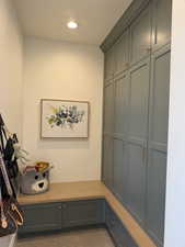 Built-in storage solutions featuring full-height cabinetry with crown molding, lower cabinetry, and an integrated wood-finish bench