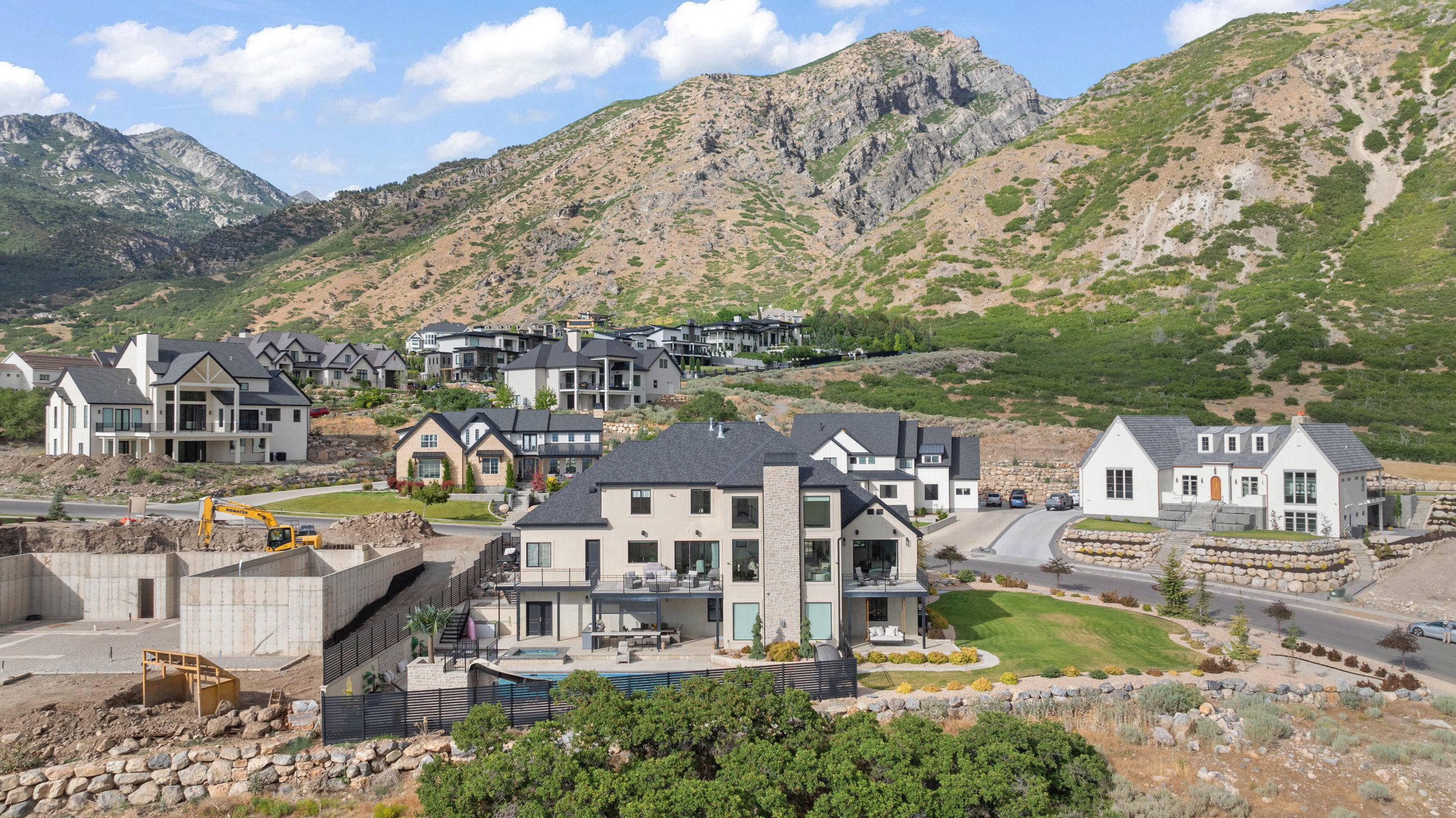 Contemporary residence featuring a multi-level design, a dark shingle roof, and a stone and stucco exterior