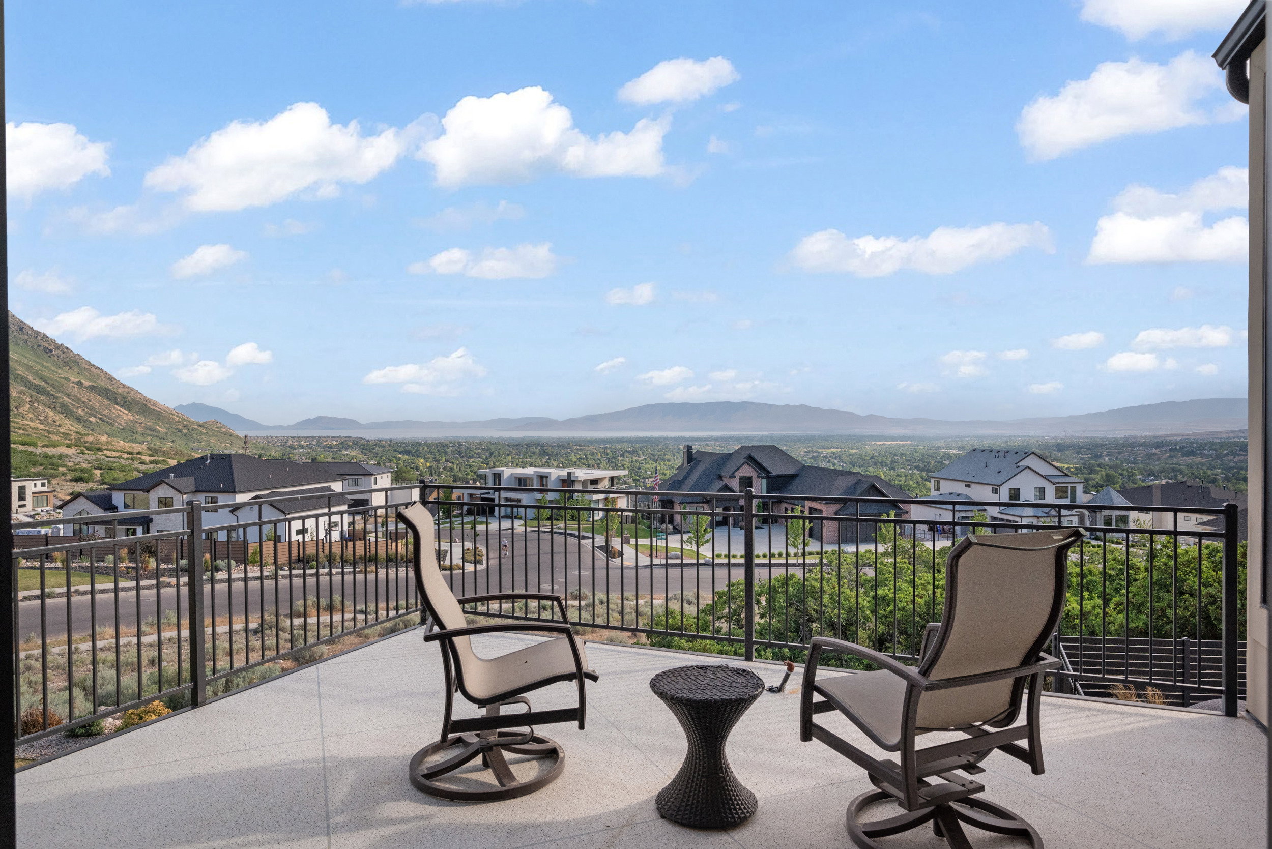 Expansive balcony featuring a textured concrete surface and sturdy metal railings