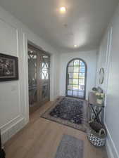 Entryway featuring light wood-finish flooring, recessed lighting, and white wainscoting