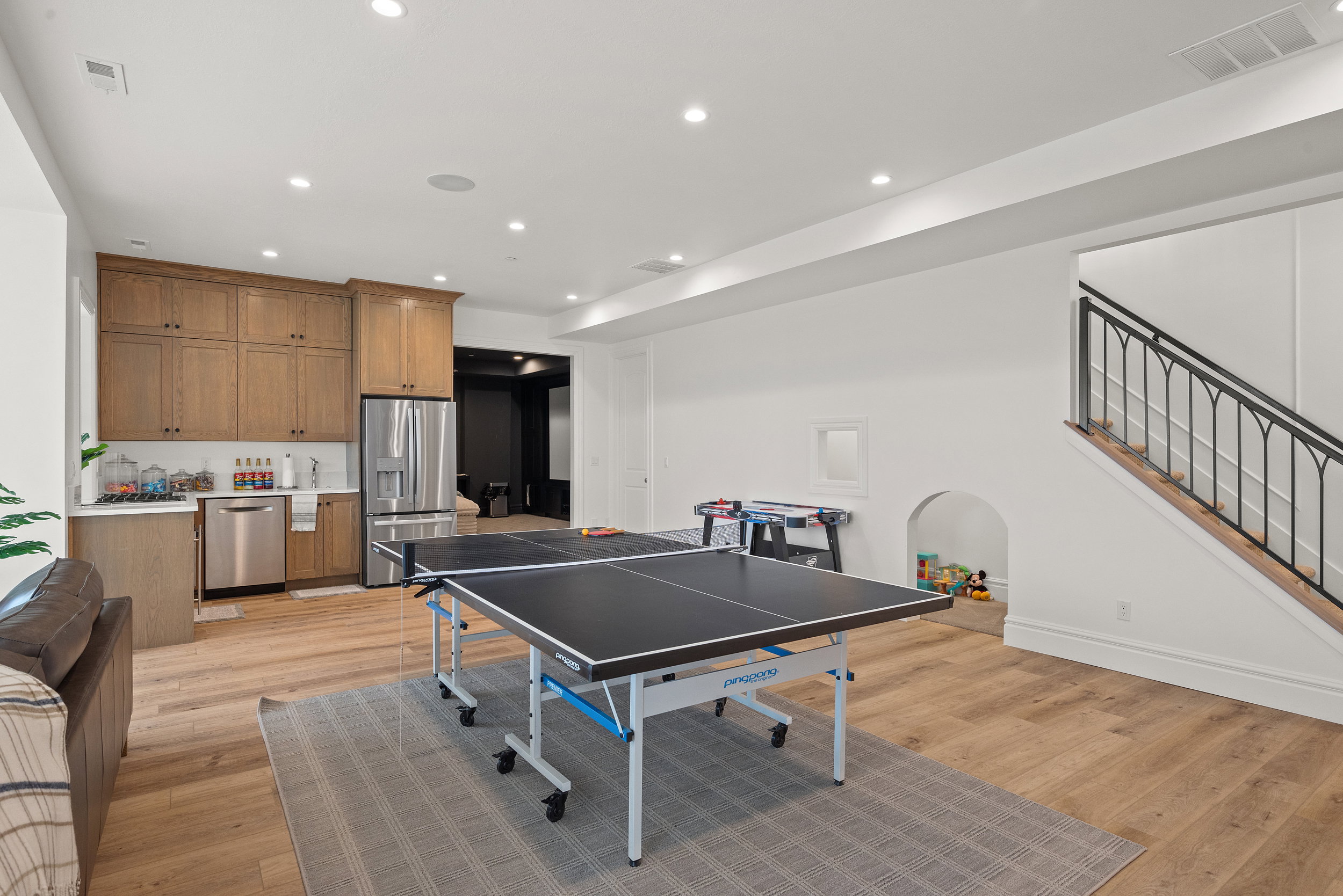 Spacious recreation room featuring wood-finish flooring and recessed lighting