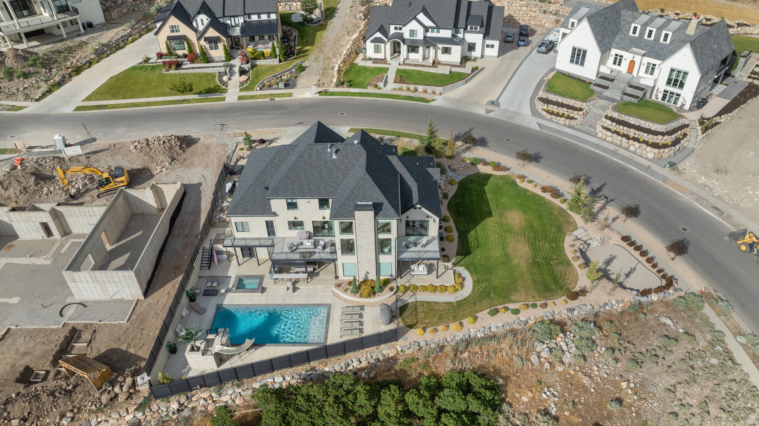Contemporary residence featuring a private pool, an integrated spa, multiple deck areas, a manicured lawn, and professional landscaping