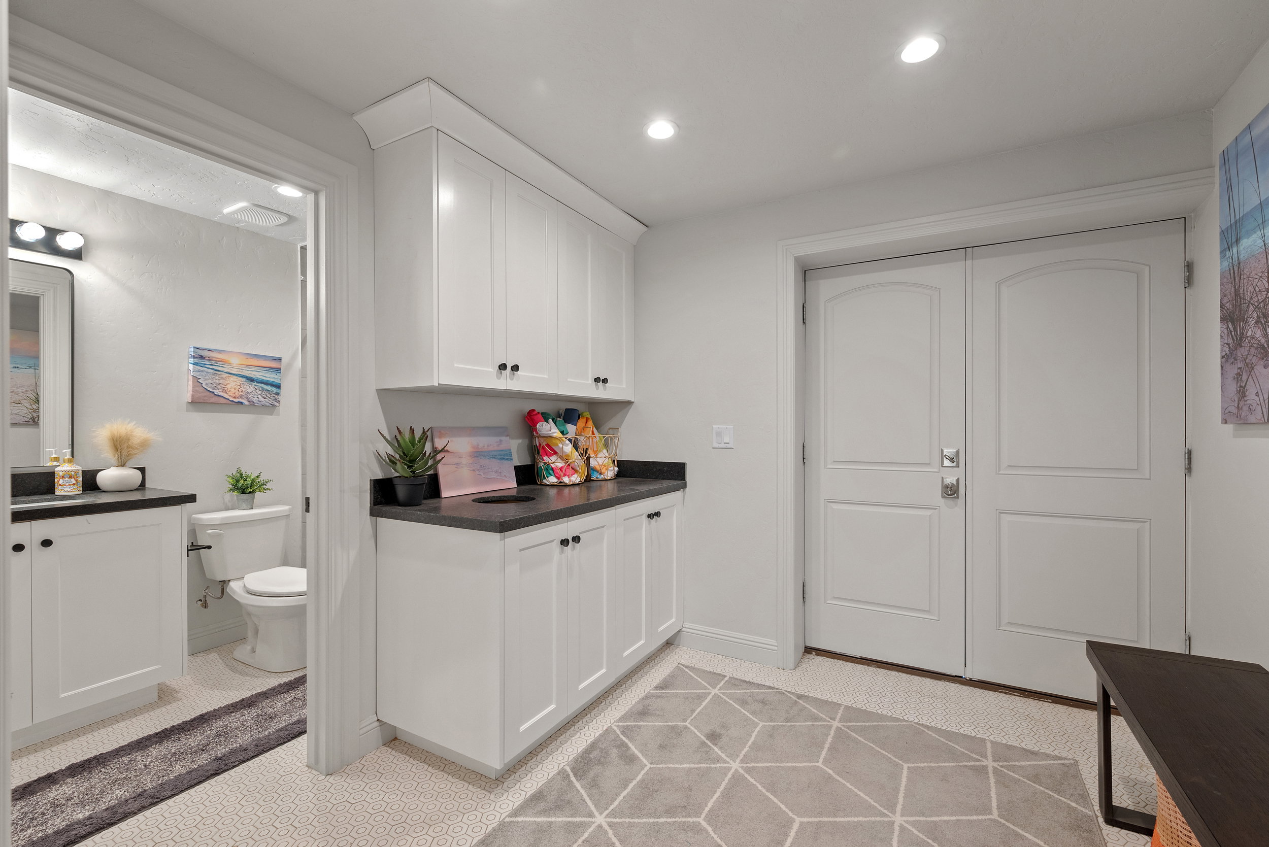 White cabinetry with dark countertops, recessed lighting, and double-paneled doors