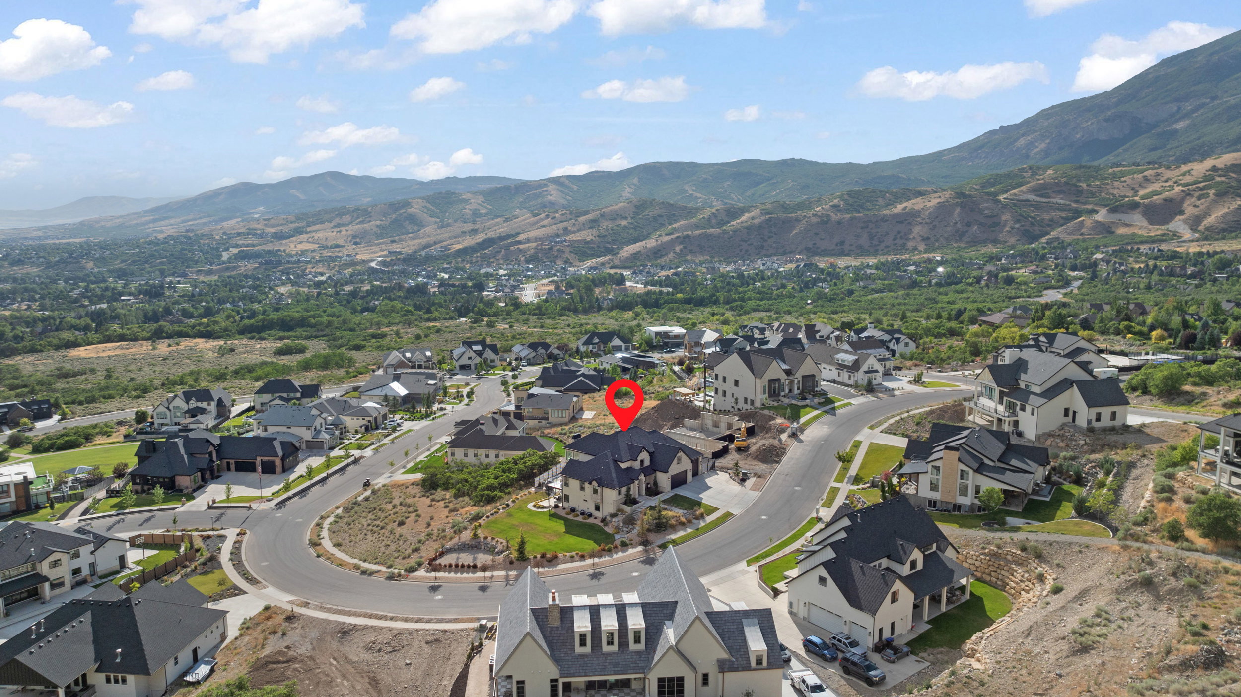 Aerial view showcasing a residential neighborhood with mountain scenery