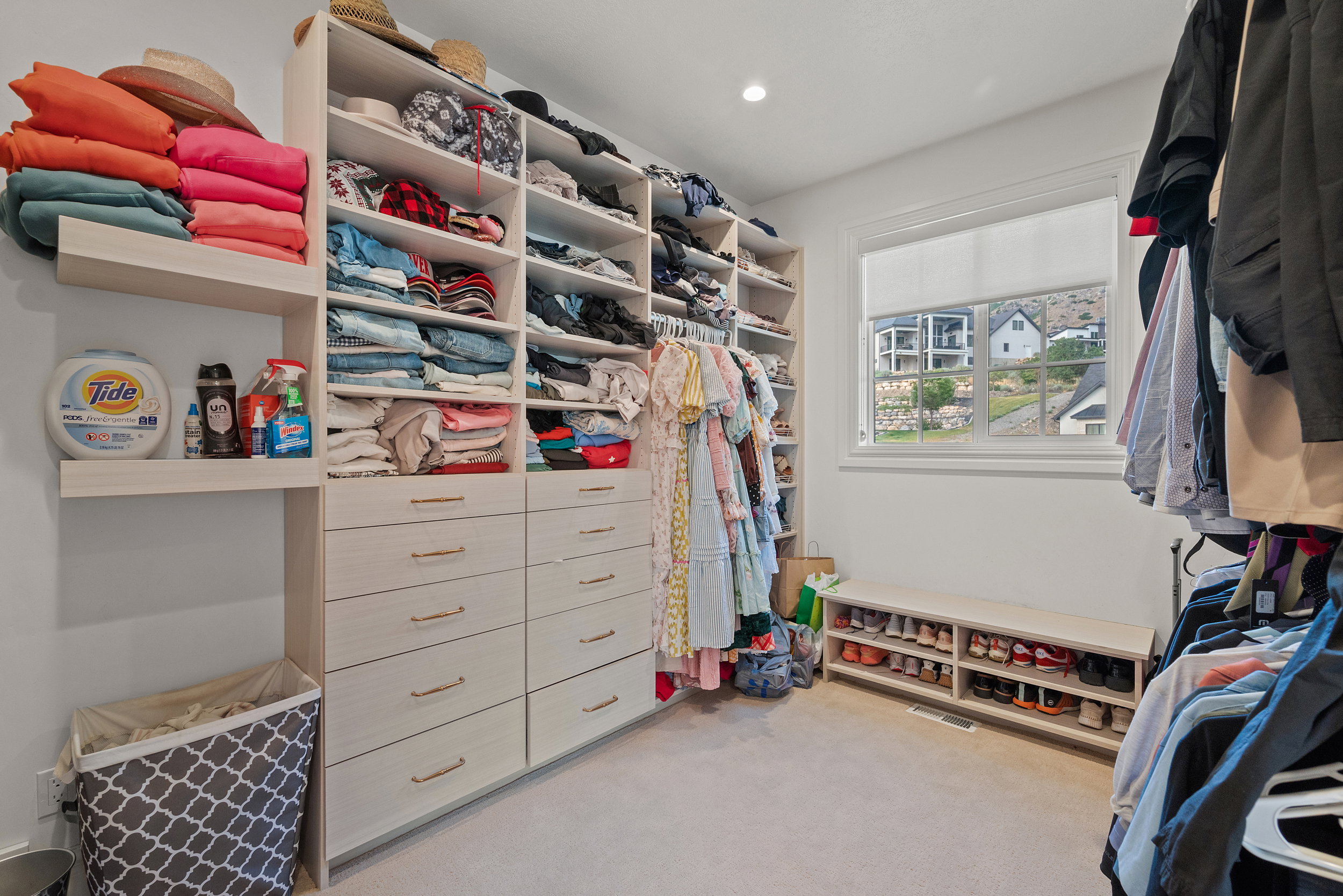 Custom built-in storage solutions featuring shelving, drawers with modern hardware, and hanging rods