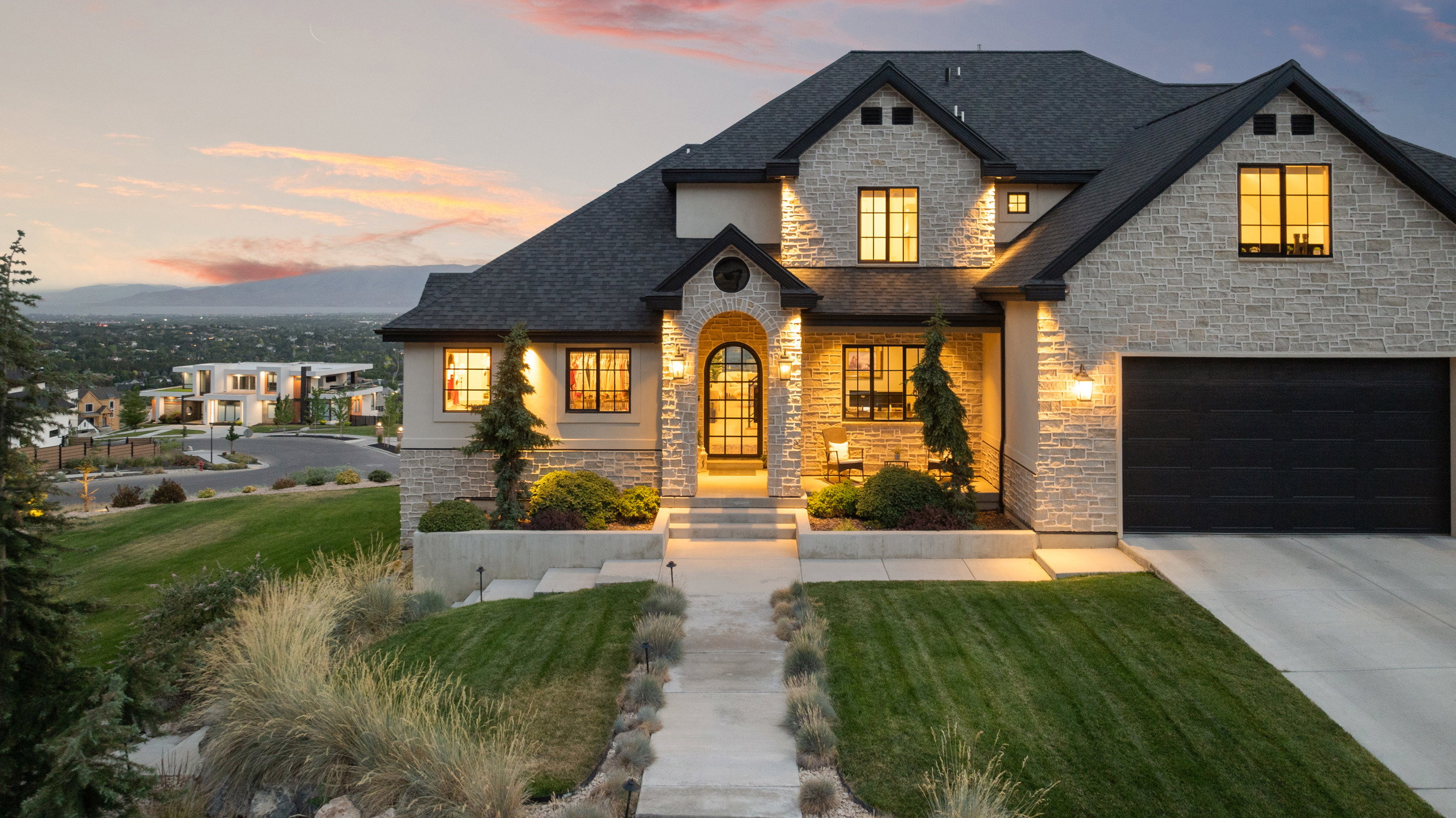 Stone veneer and stucco exterior with dark trim accents