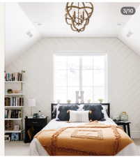 Sloped ceiling room featuring white shiplap walls, a large window with white trim, and a decorative wood-finish chandelier