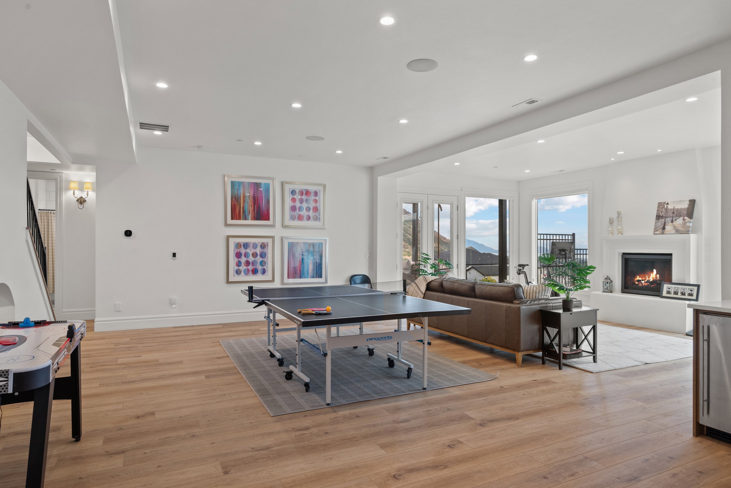 Open-concept recreation area featuring wood-finish flooring, recessed lighting, and a white baseboard trim