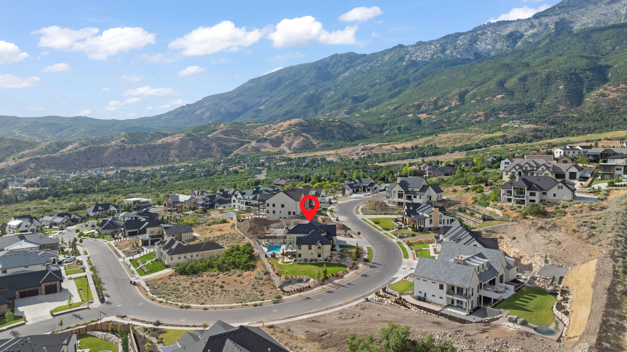 Aerial perspective showcasing a residential community nestled against a mountainous backdrop