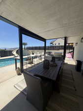 Covered patio with integrated outdoor kitchen, bar seating, and a refreshing pool