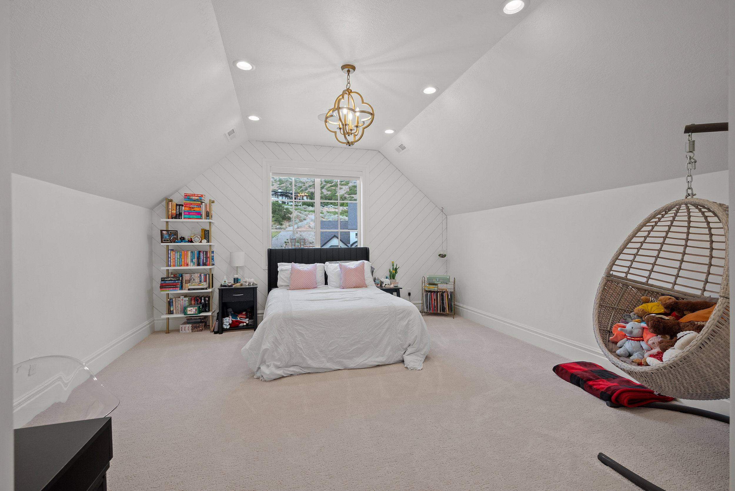 Spacious room with a vaulted ceiling, recessed lighting, and an ornate ceiling fixture