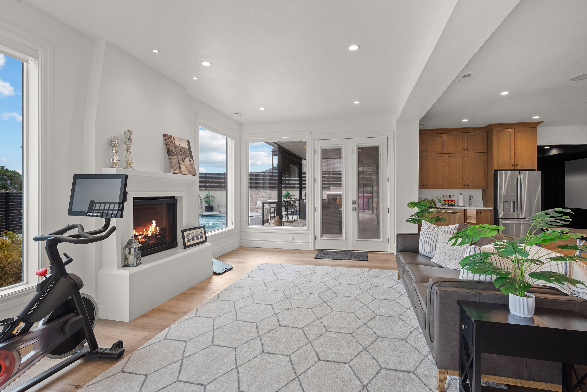 Living area with a built-in fireplace, light wood-finish flooring, recessed lighting, and large windows