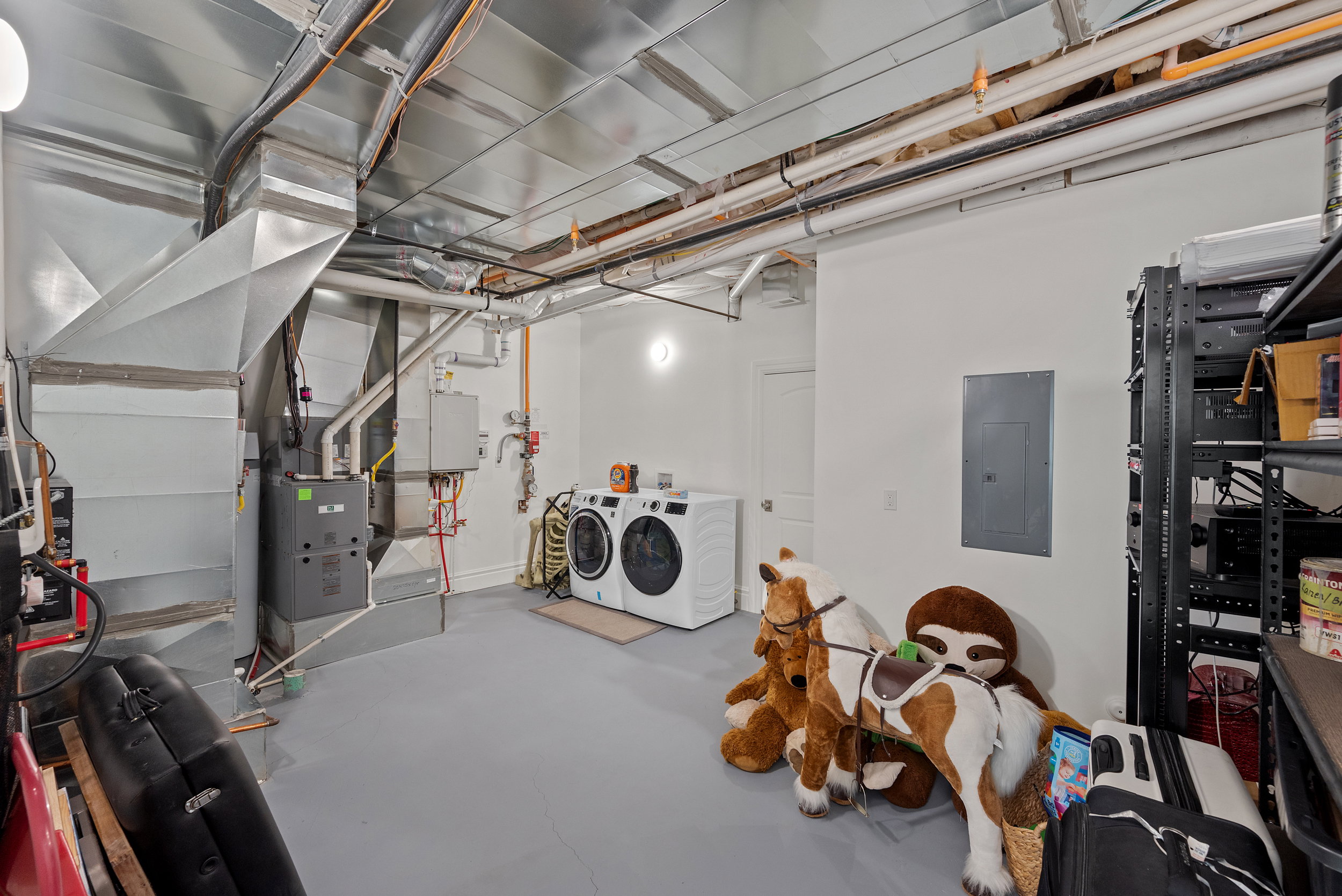 Laundry area featuring a stackable washer and dryer, utility sink, and overhead lighting
