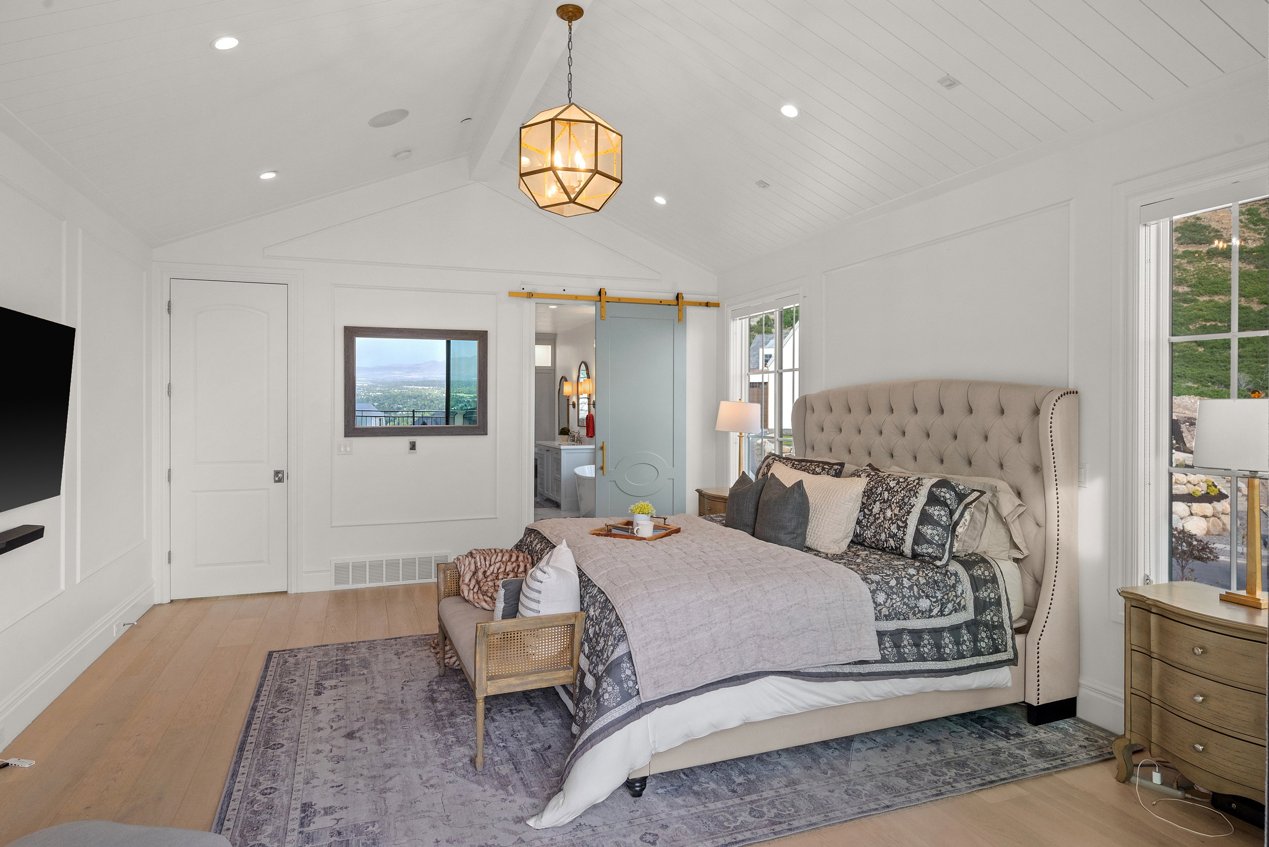 Vaulted shiplap ceiling with recessed lighting and a central geometric pendant fixture