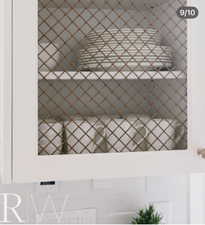 White cabinetry featuring decorative wire mesh inserts, brushed nickel hardware, and a white subway tile backsplash