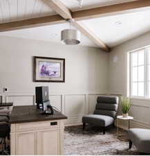 Vaulted ceiling with exposed wood beams and white plank detailing, complemented by a drum pendant light fixture