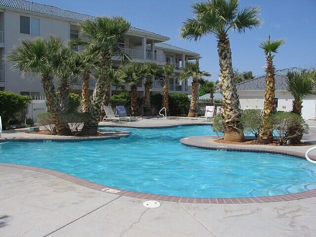 Freeform swimming pool with a concrete deck and red brick coping