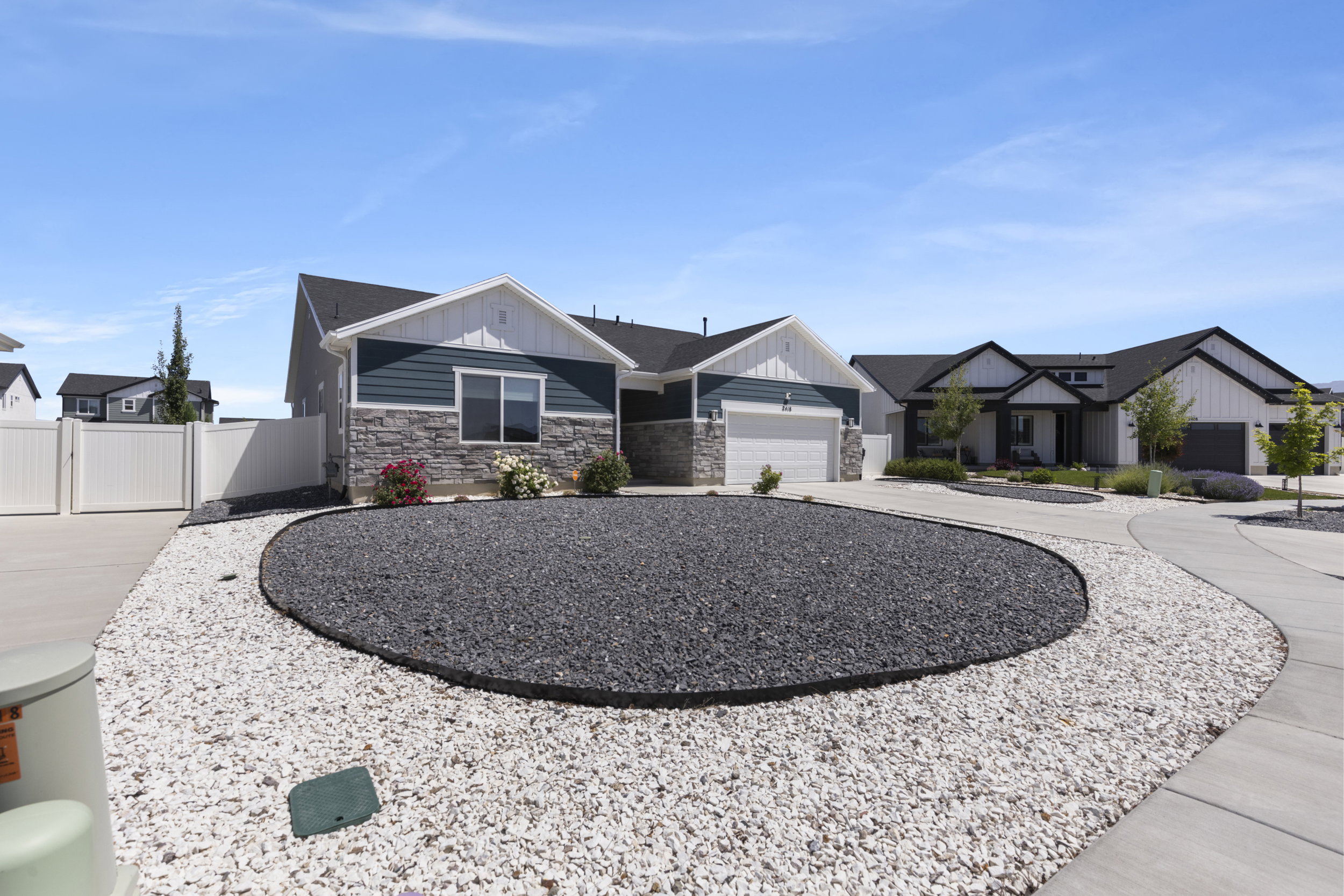 Modern single-story residence featuring a two-car garage and a combination of horizontal siding and stone veneer