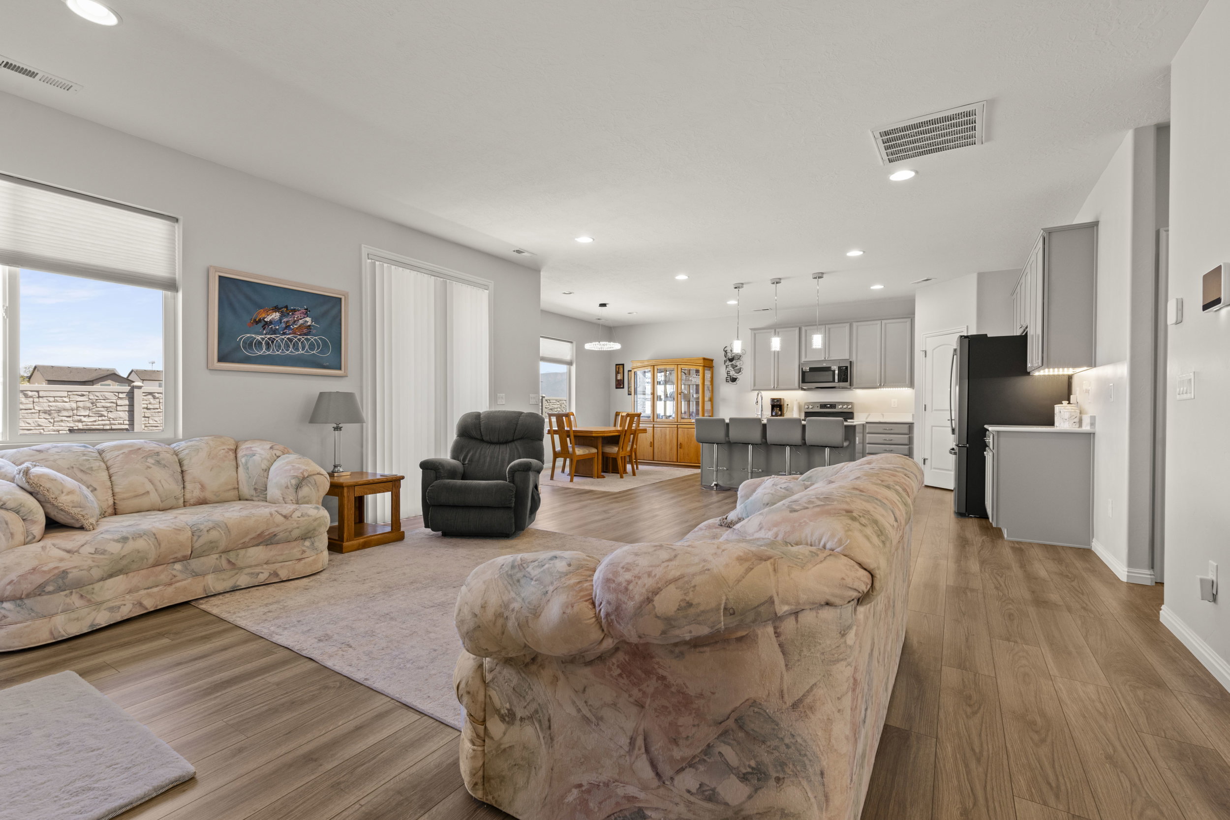 Open-concept living space featuring wood-finish flooring and recessed lighting