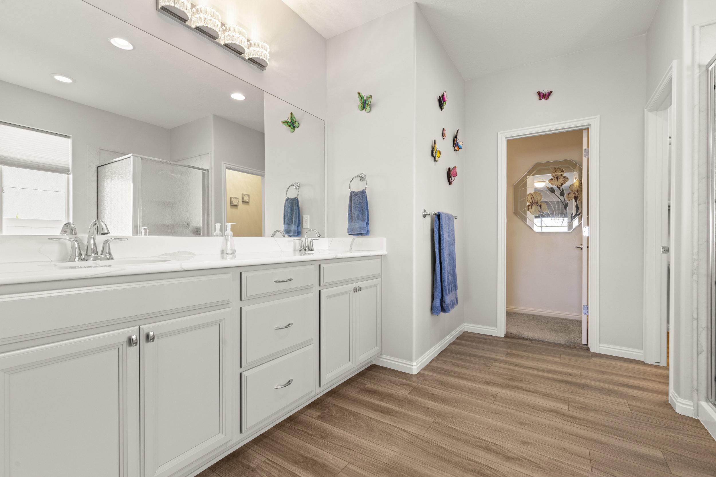 Dual vanity with light cabinetry and solid surface countertop