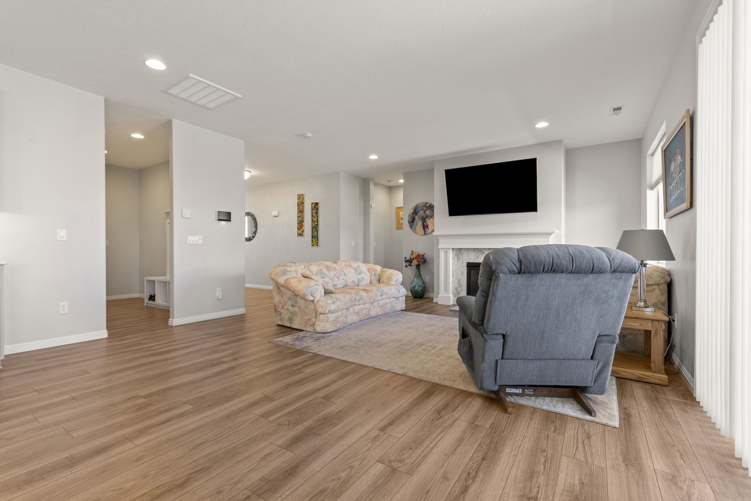 Spacious room featuring wood-finish flooring, recessed lighting, and light gray wall paint