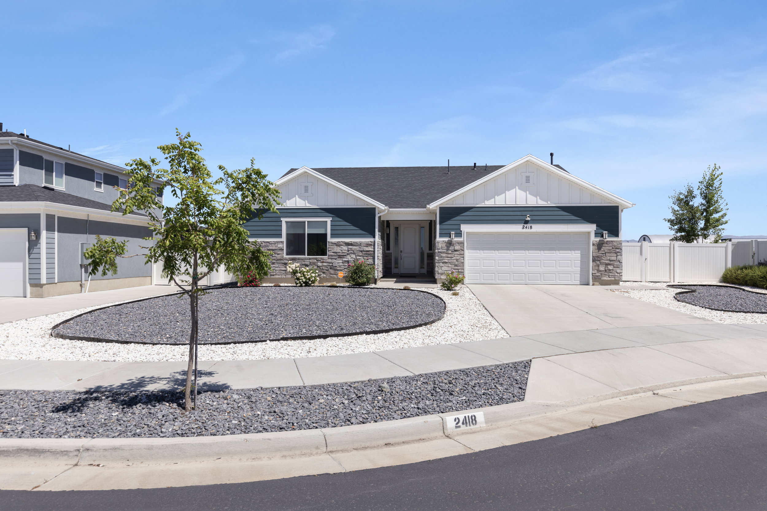 Contemporary ranch-style residence featuring blue siding, white trim, and stone accents