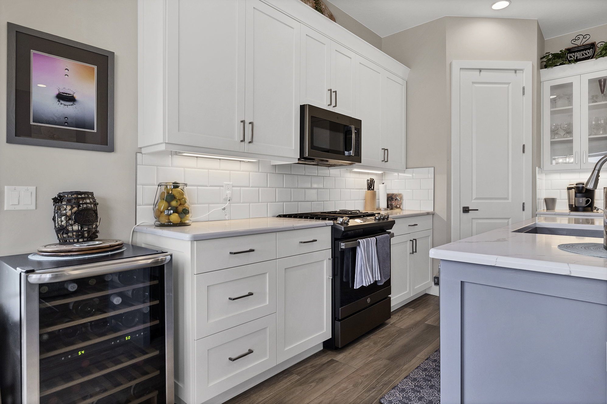 Contemporary kitchen featuring white shaker cabinetry and coordinating subway tile backsplash